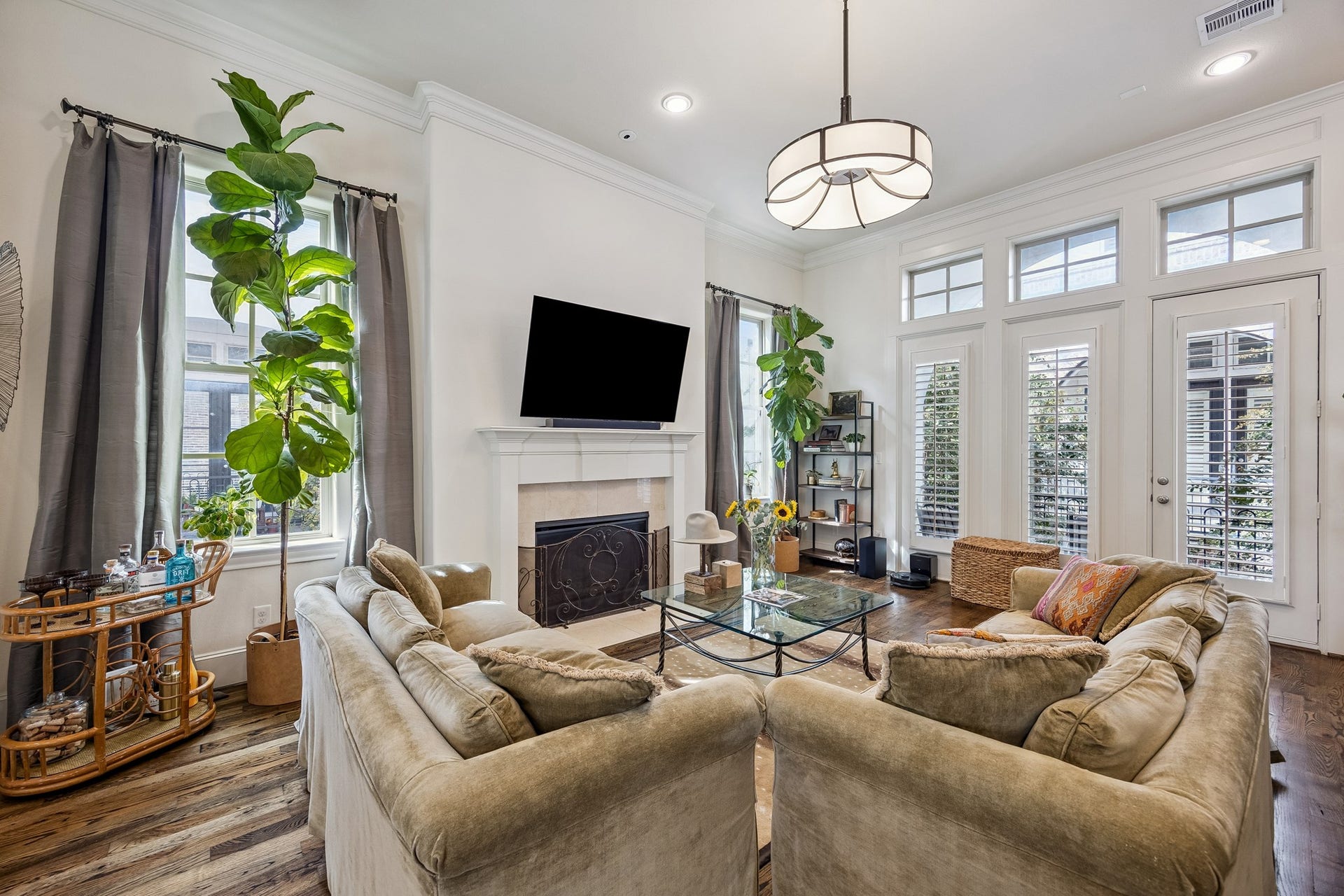 2721 Cohn Street, Houston, TX 77007 Natural light fills the living room through tall windows & transoms, complemented by wood floors, high ceilings & an eye-catching light fixture.