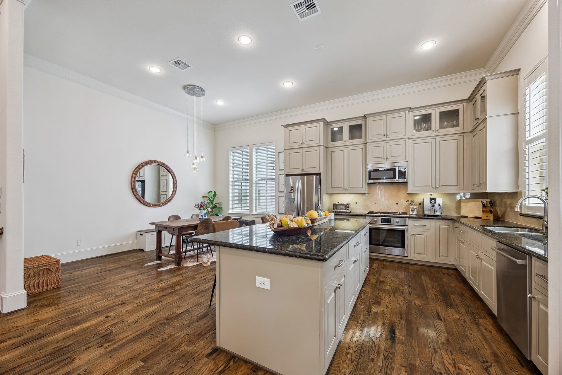 2721 Cohn Street, Houston, TX 77007 Another view showcases the kitchens impressive storage, including cabinetry extending to the ceiling, glass-front display cabinets, granite countertops & a spacious island w/additional drawers & cabinetry.
