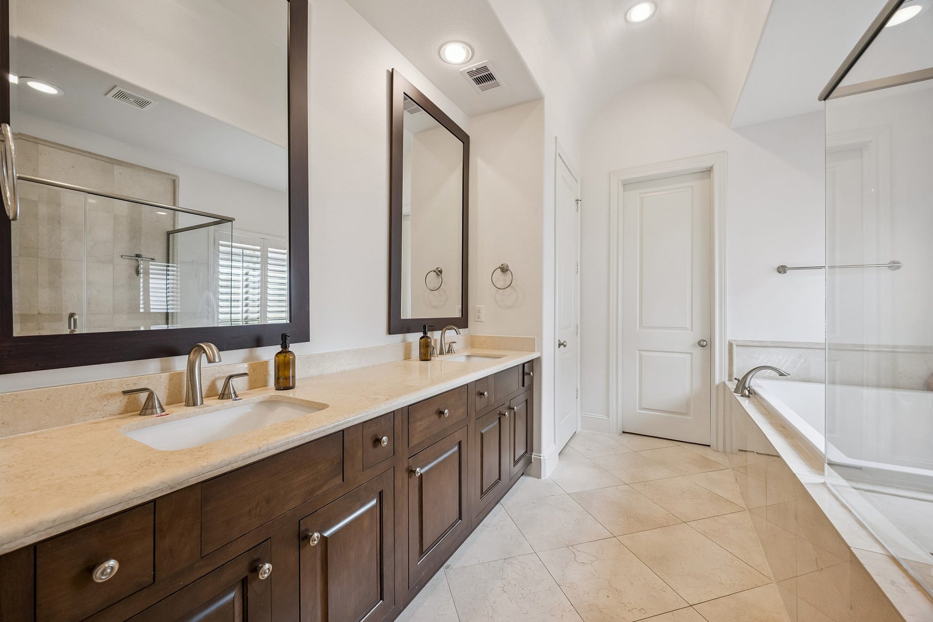 2721 Cohn Street, Houston, TX 77007 Spacious primary bath features a long dual-sink vanity w/extensive cabinetry & counter space, stone flooring, recessed lighting & access to a large walk-in closet.