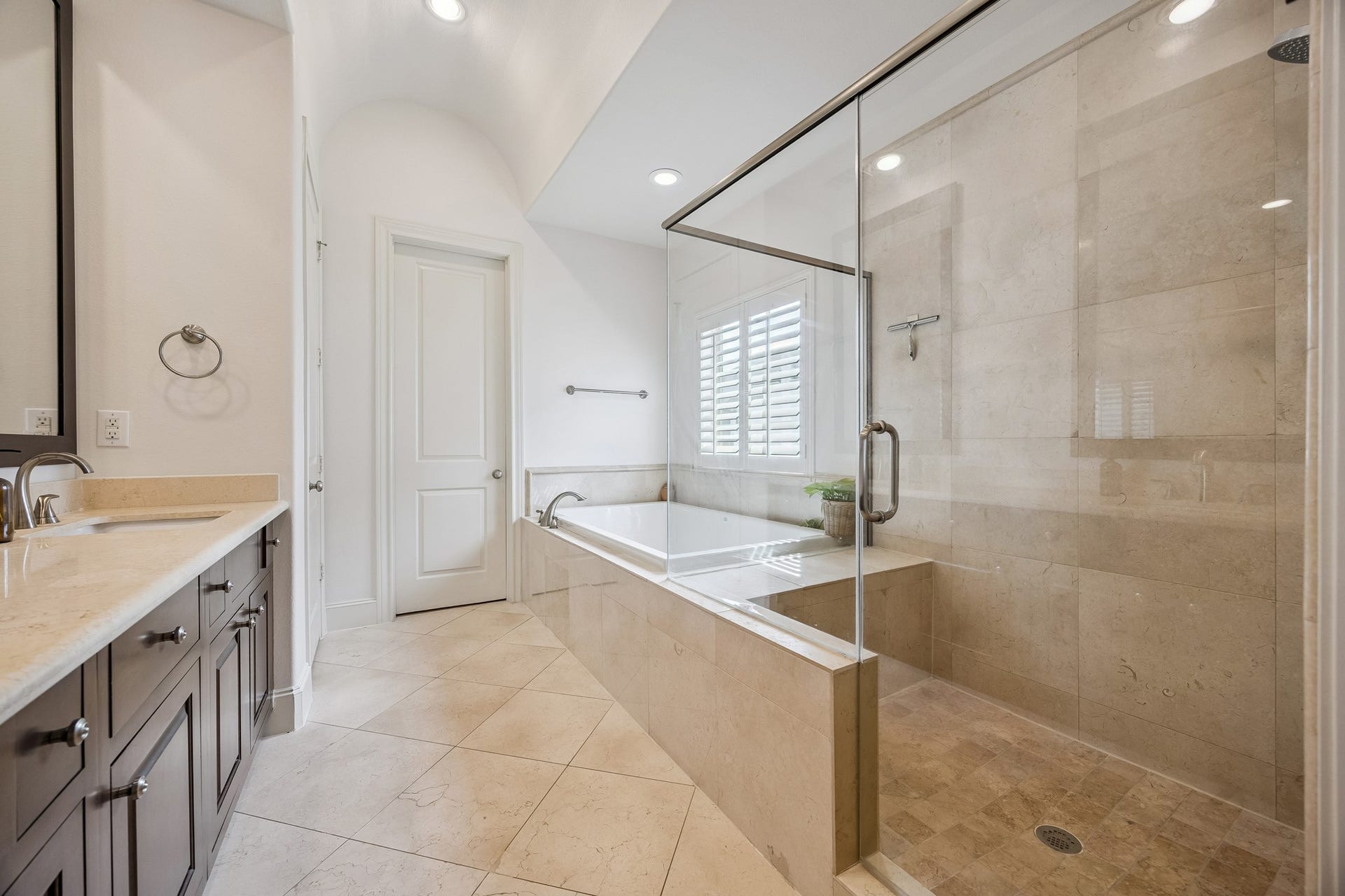 2721 Cohn Street, Houston, TX 77007 Glass-enclosed walk-in shower features stone surround & flooring, positioned alongside the soaking tub for a well-designed bath layout.