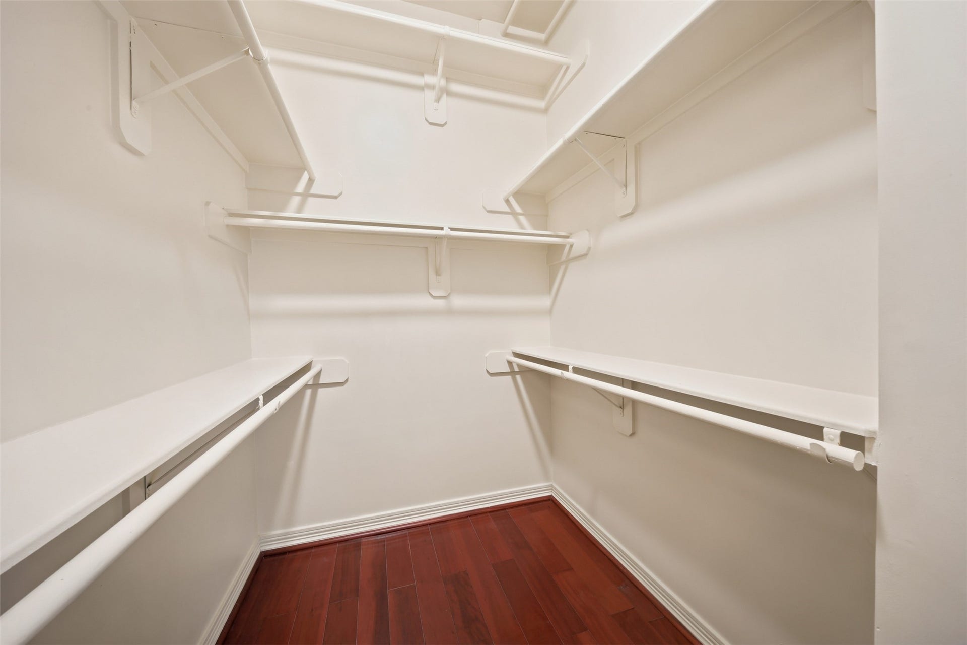 26306 Eden Point Court, Katy, TX 77494 Second primary walk-in closet with hardwood flooring and generous double-sided hanging and shelf storage.