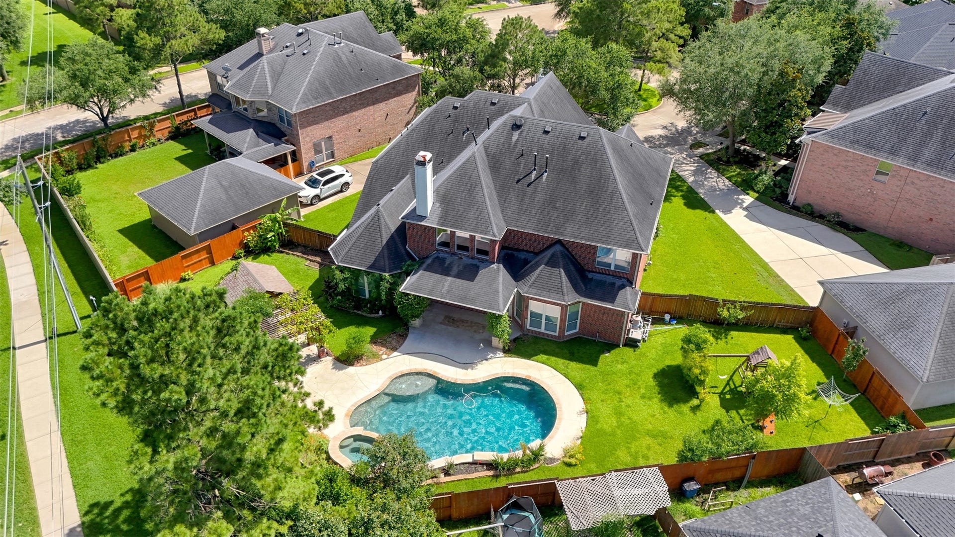 26306 Eden Point Court, Katy, TX 77494 Top-down aerial showing the roofline, pool and spa, covered patio, landscaped yard, and surrounding residential setting.