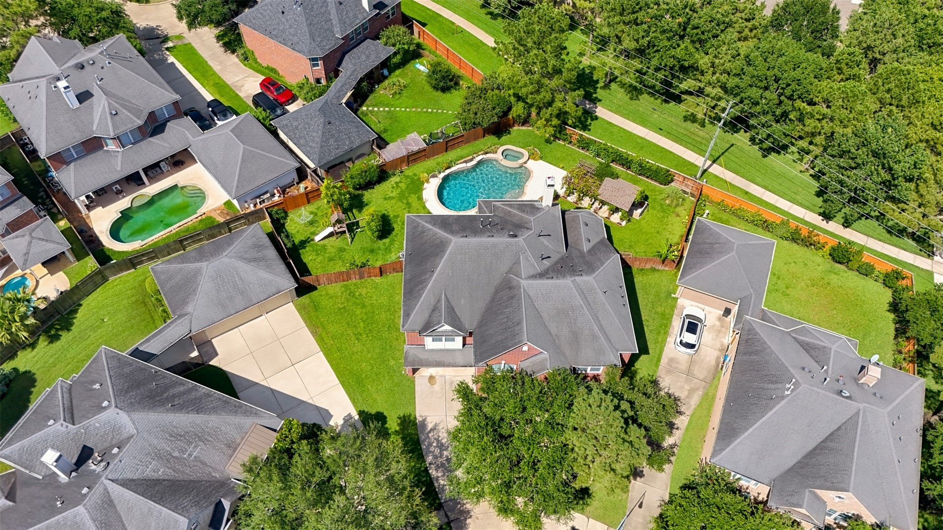 26306 Eden Point Court, Katy, TX 77494 Aerial view highlighting the homes substantial footprint, expansive backyard, pool and spa, lawn areas, and nearby greenbelt trail.