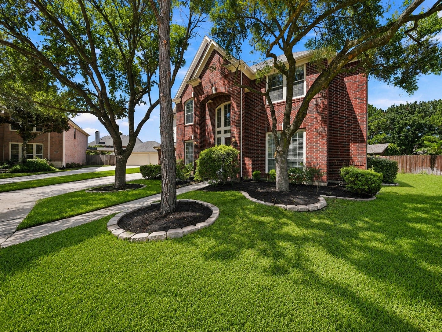 26306 Eden Point Court, Katy, TX 77494 Angled front view highlighting the brick exterior, architectural detailing, established trees, and spacious lawn.