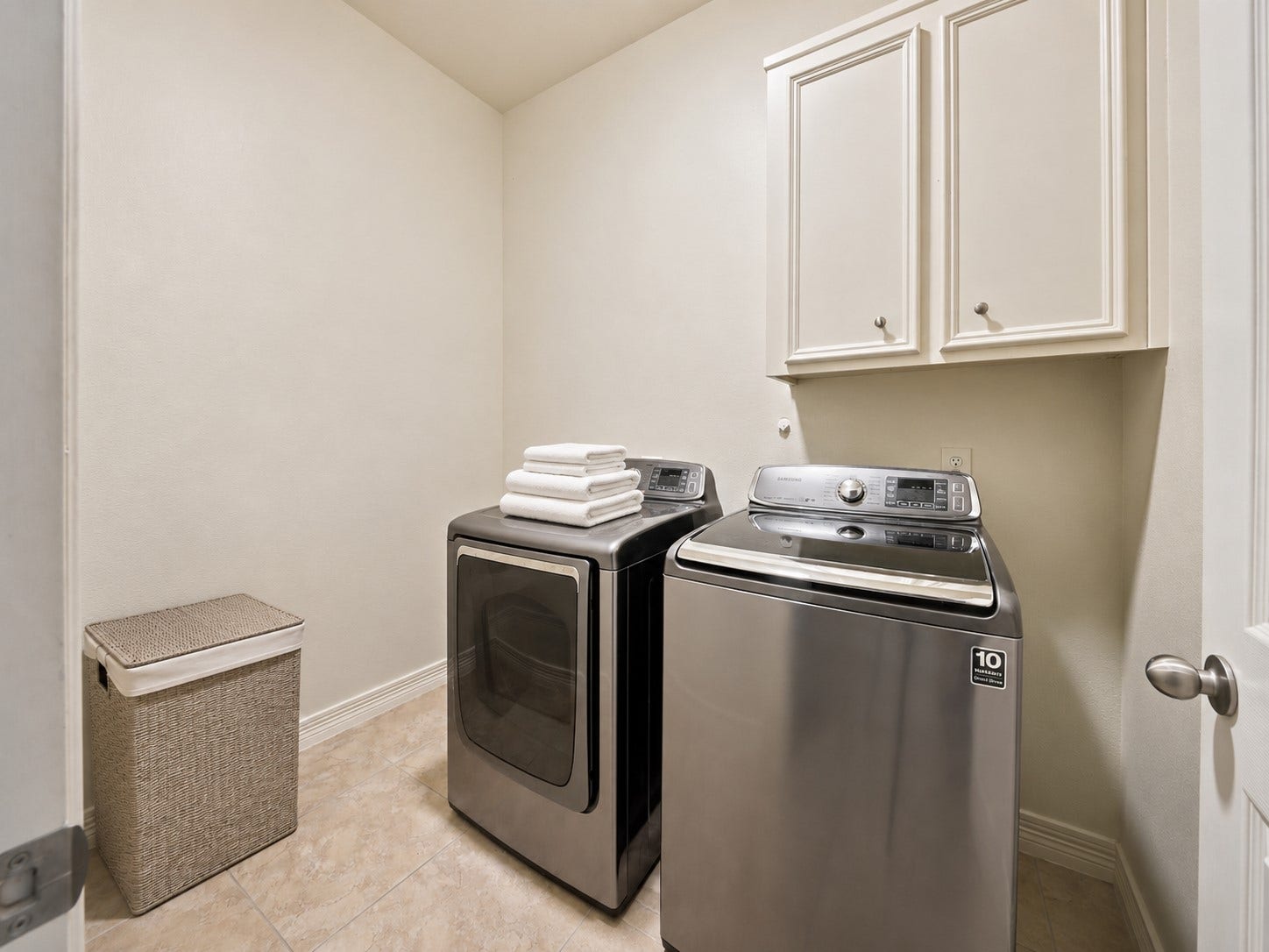 26306 Eden Point Court, Katy, TX 77494 Utility room with tile flooring, overhead cabinetry, and space for a full-size washer and dryer.