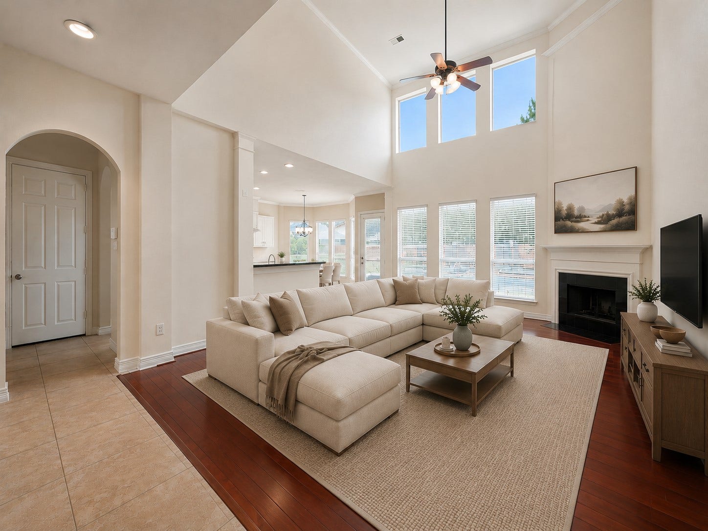 26306 Eden Point Court, Katy, TX 77494 Two-story family room with hardwood flooring, a fireplace, ceiling fan, and tall windows providing abundant natural light.