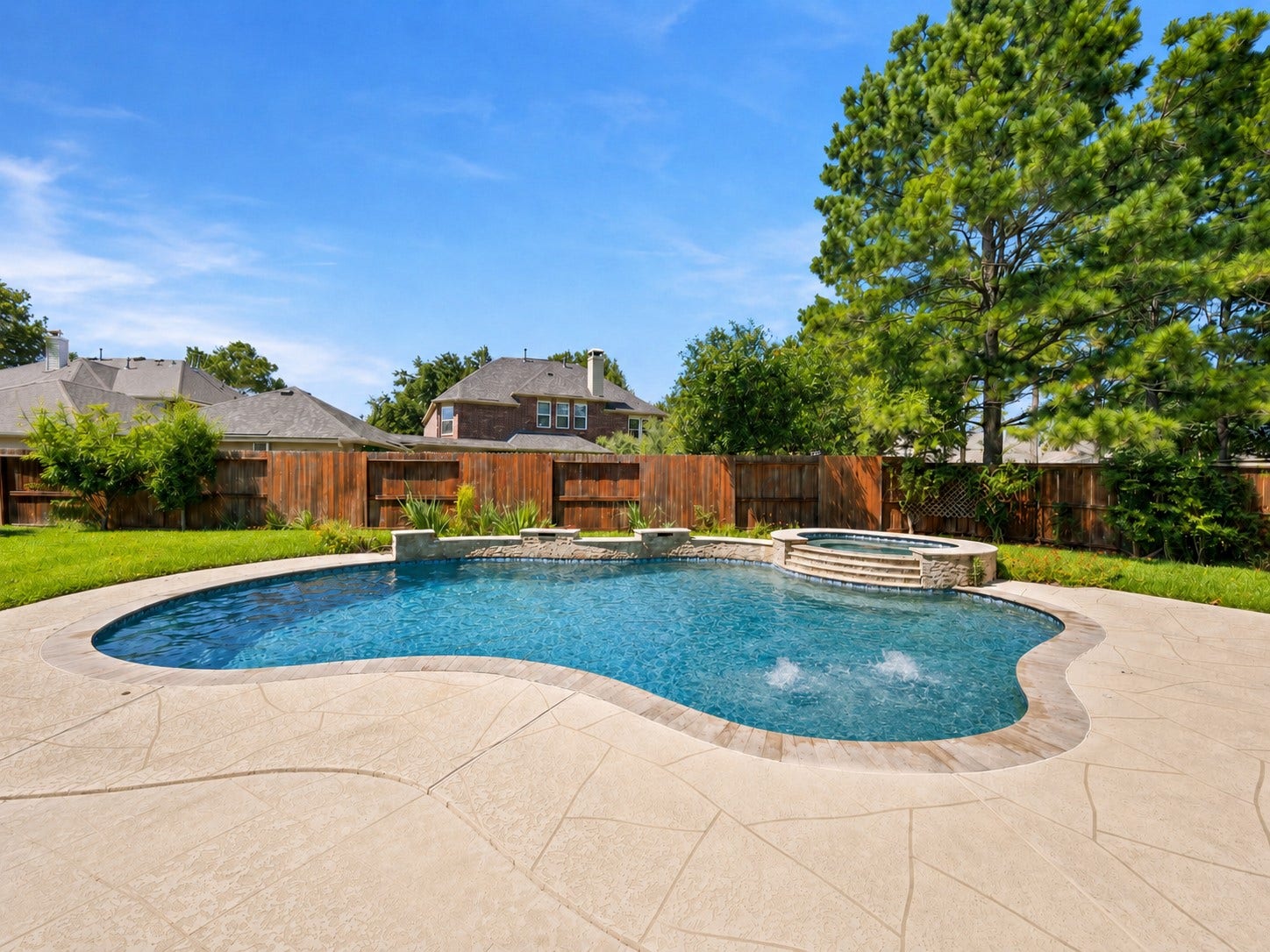 26306 Eden Point Court, Katy, TX 77494 Freeform pool with an elevated spa, water features, and an expansive surrounding deck.