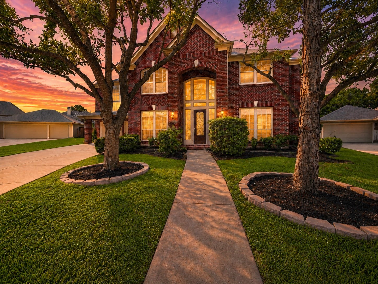 26306 Eden Point Court, Katy, TX 77494 Welcoming front elevation with red brick, distinctive herringbone accents, a two-story arched entry, mature shade trees, and landscaped grounds.