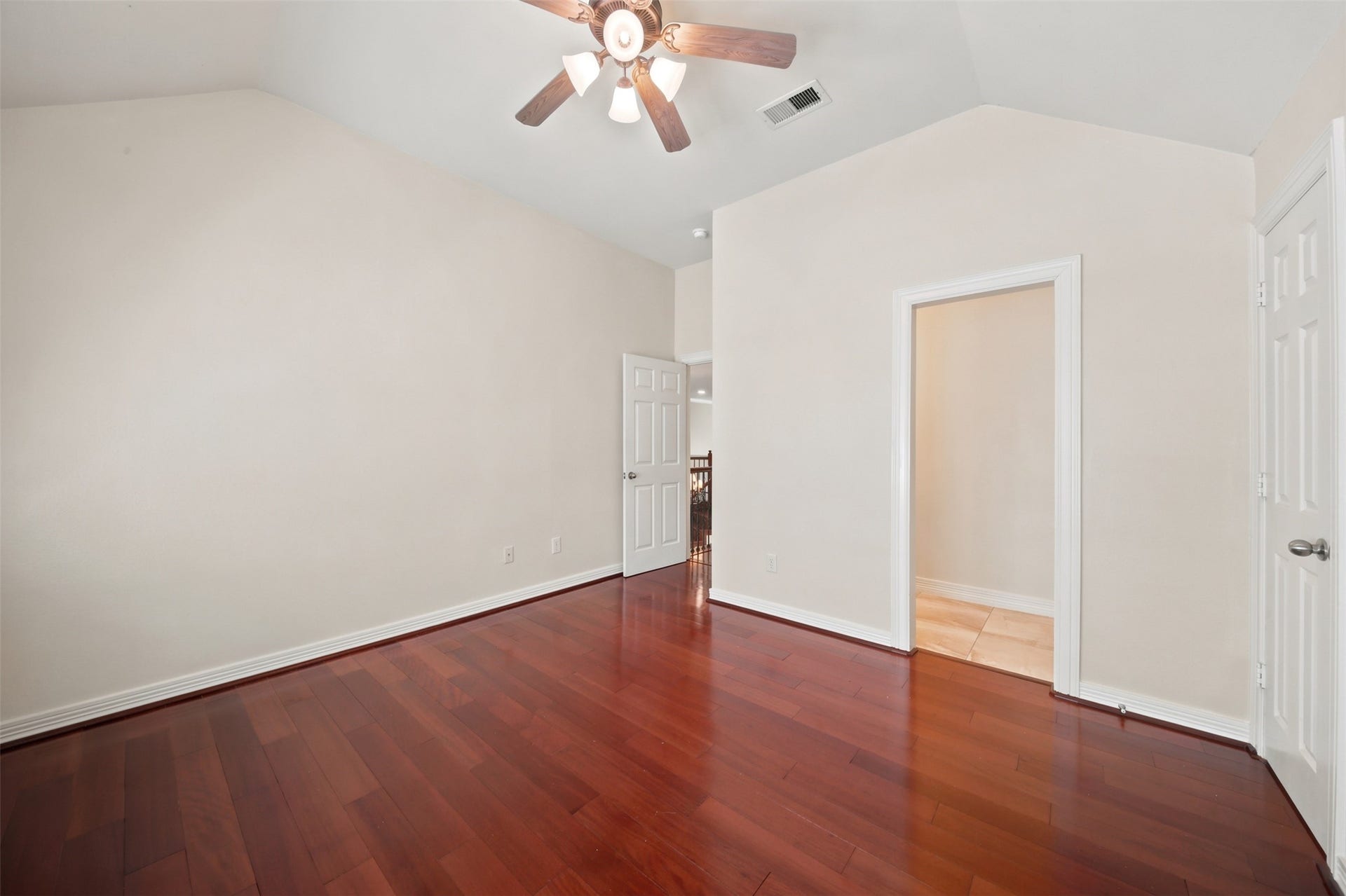 26306 Eden Point Court, Katy, TX 77494 Alternate bedroom view highlighting the vaulted ceiling, hardwood flooring, closet, and access to the private vanity.
