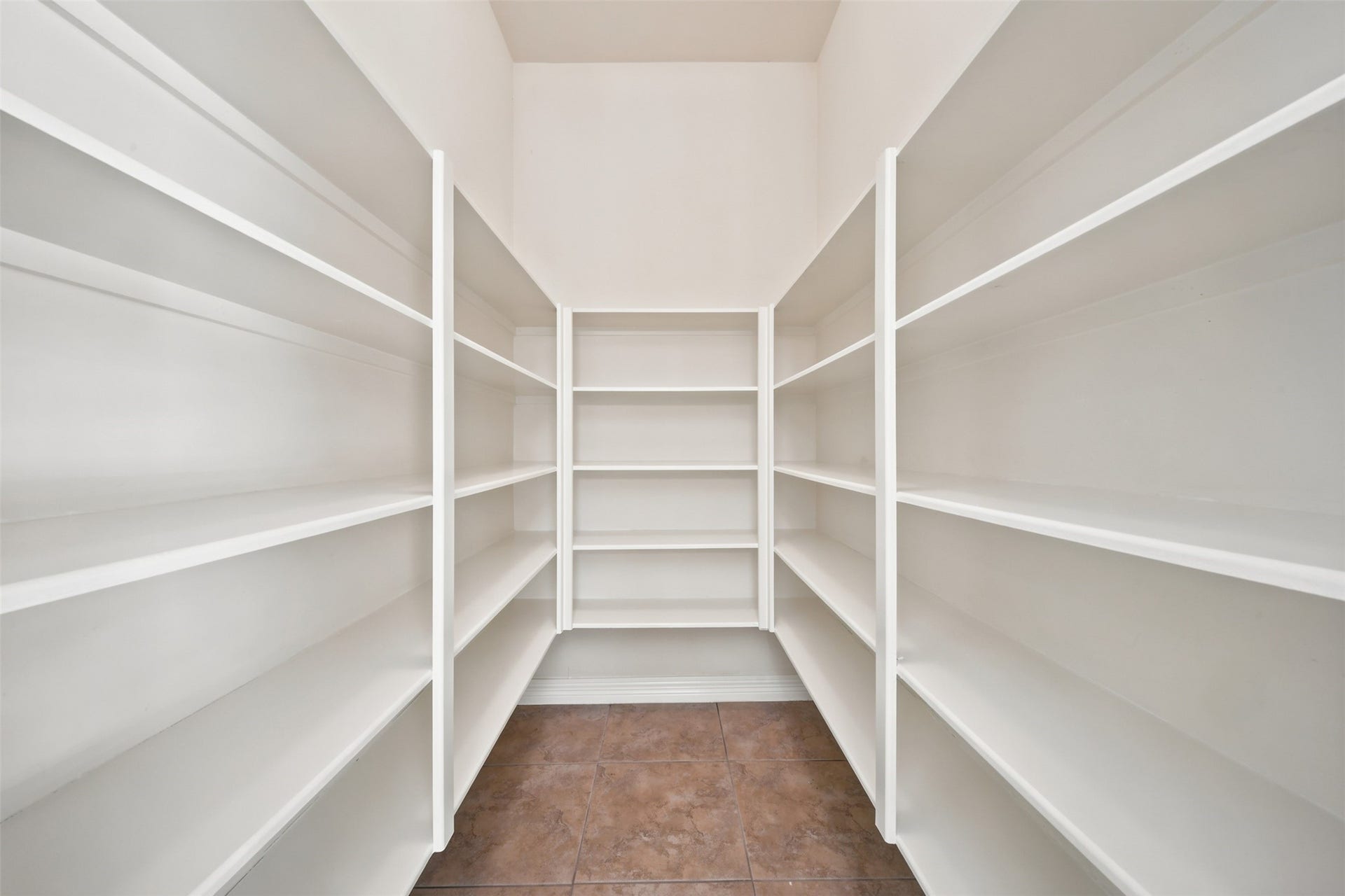 26306 Eden Point Court, Katy, TX 77494 Walk-in pantry with tile flooring and extensive built-in shelving for organized storage.