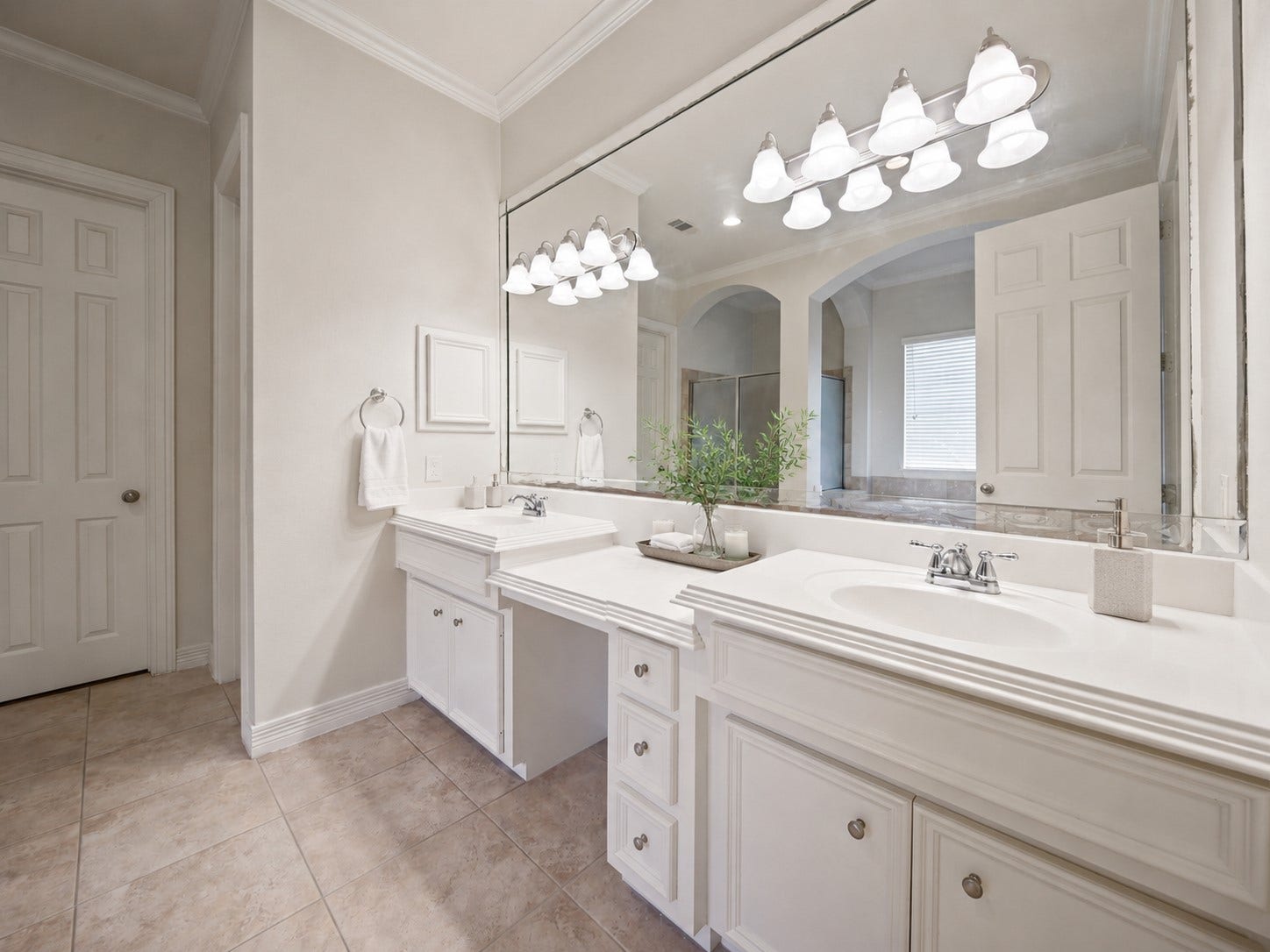 26306 Eden Point Court, Katy, TX 77494 Primary en suite with dual vanities, an expansive wall mirror, tile flooring, crown molding, and generous cabinet storage.