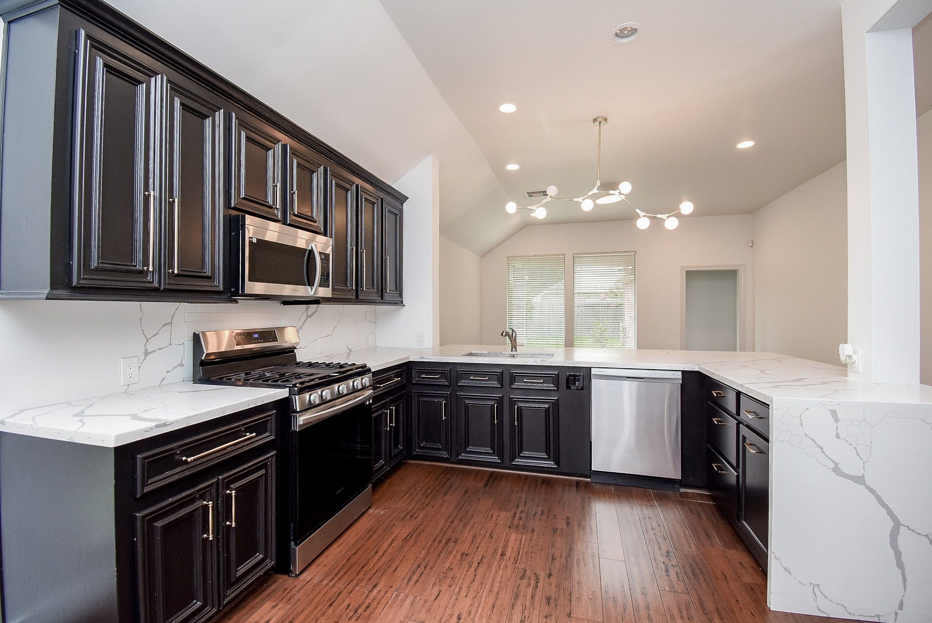 The beautifully appointed kitchen features abundant cabinetry, generous quartz countertops, stainless steel appliances, and a spacious breakfast bar. Designed with both style and functionality in mind, it opens seamlessly to the breakfast area and family room, creating the perfect space for everyday living and entertaining.