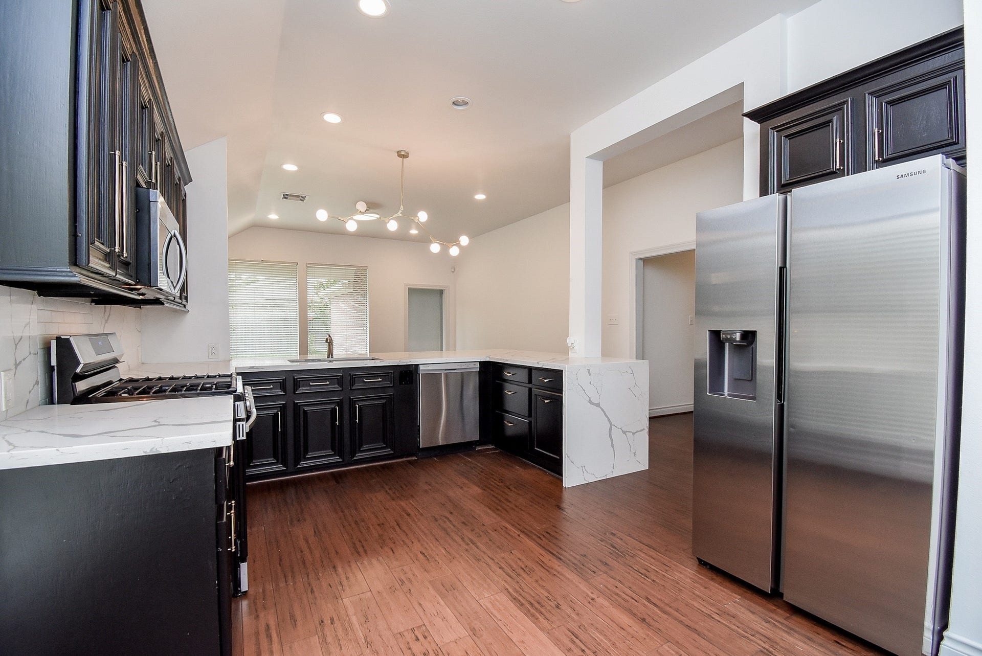Designed with both beauty and functionality in mind, this spacious kitchen offers abundant cabinetry, expansive quartz countertops, stainless steel appliances, and an efficient layout that makes meal preparation and entertaining effortless.