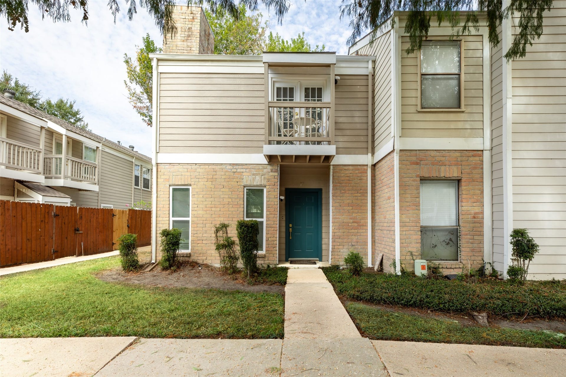 Discover the inviting charm of Cobblestone Court Townhomes, where a gated entrance and lush greenery create a serene and secure living environment.