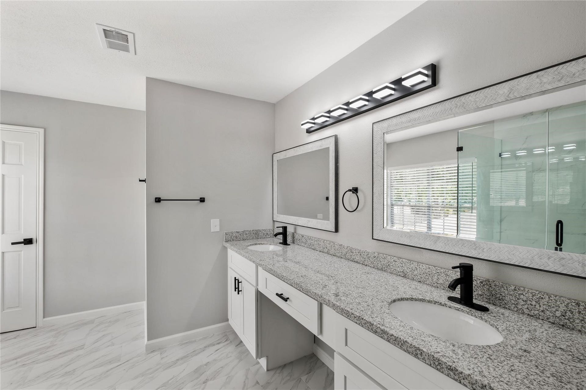 4523 Waterfall Way, Sugar Land, TX 77479 The renovated primary bathroom features dual sinks, granite countertops, updated fixtures, and a spacious walk-in shower.
