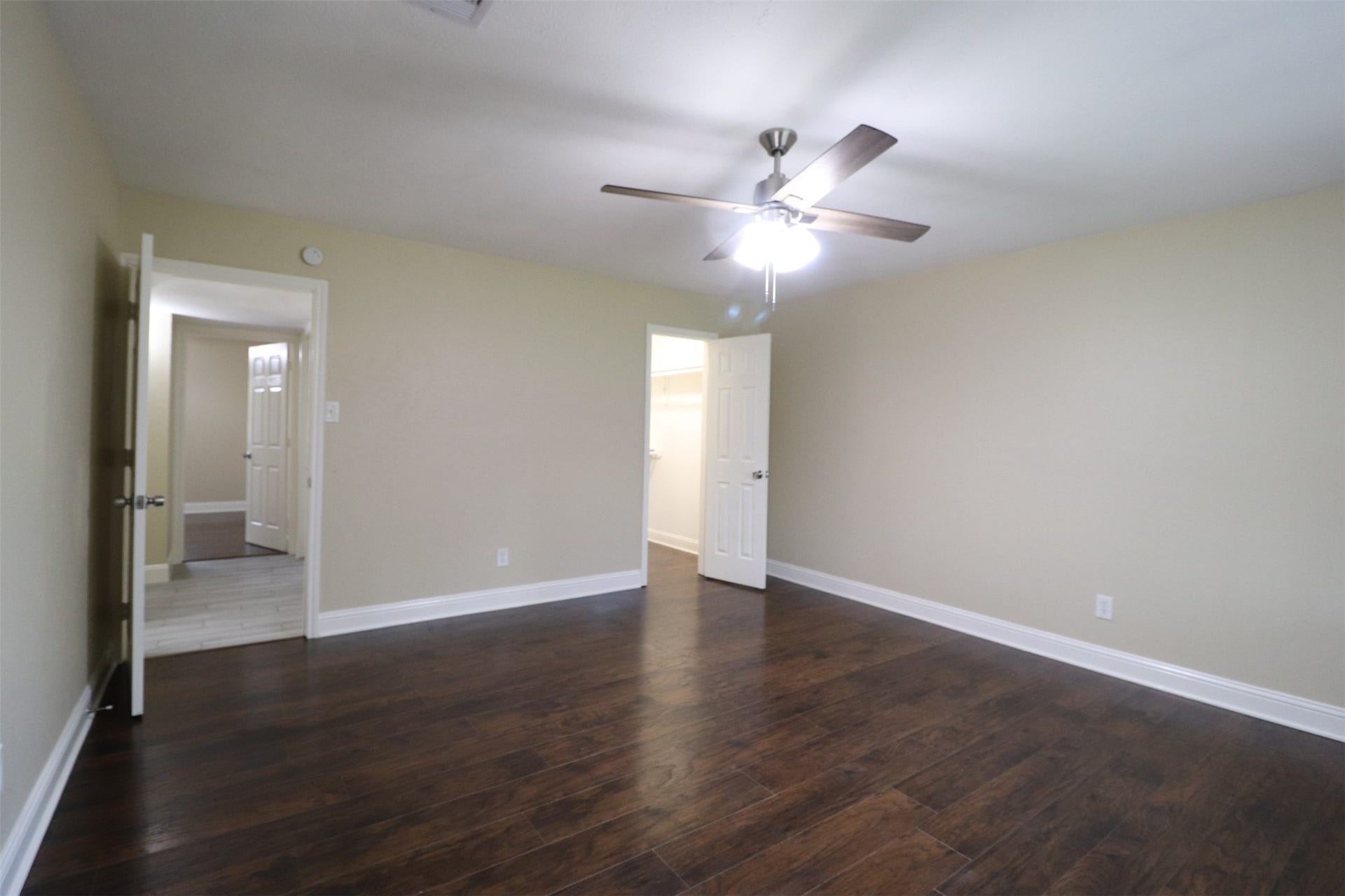 Primary bedroom with walk-in closet to the right and hallway to the left.