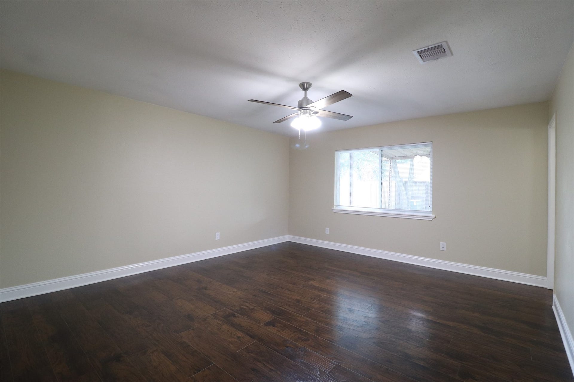 Primary bedroom overlooking the backyard, en-suite bathroom to the right.