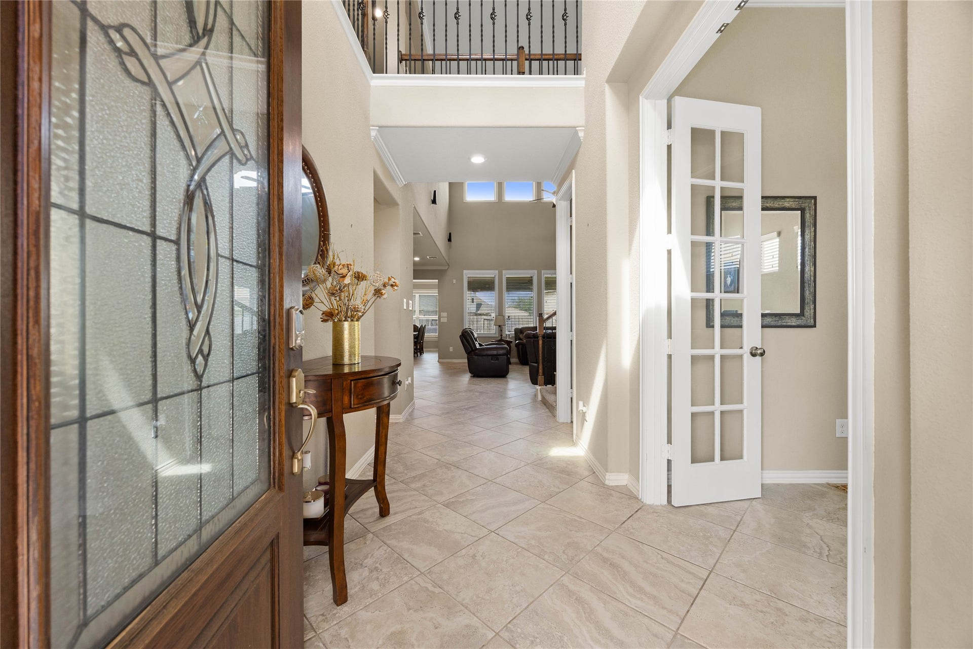 18707 Fox Kestrel Trail, Cypress, TX 77429 Elegant entryway with tiled floors, high ceilings, and abundant natural light, leading to a spacious living area. French doors open to a versatile room, perfect for an office or study.