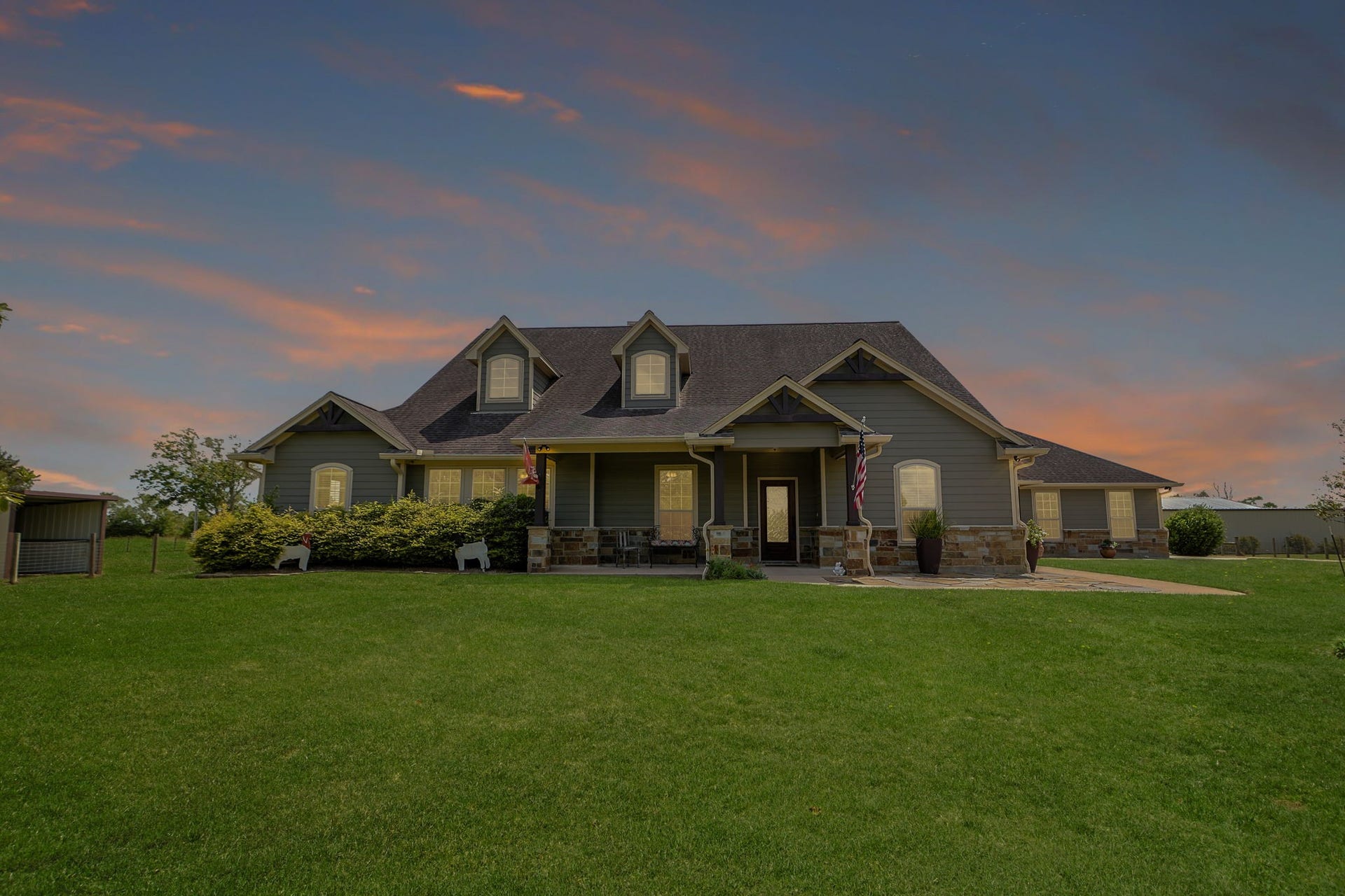 Charming home with a classic gabled roof and inviting front porch, set against a picturesque sunset sky.