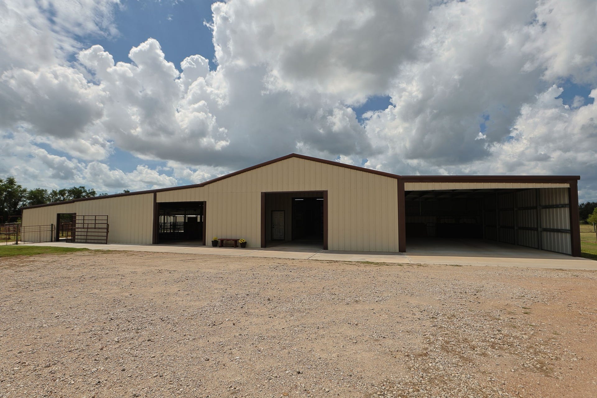 Expansive metal barn with open bays, perfect for storage or agricultural use, set against a backdrop of vast skies and natural surroundings.