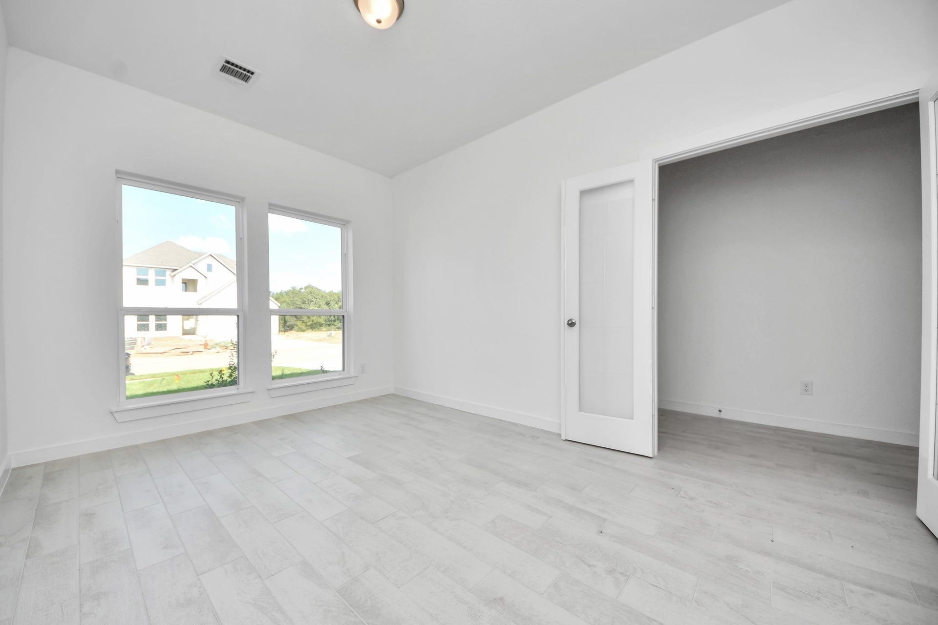 3064 Spoolwood Trail, Magnolia, TX 77355 Experience the perfect blend of sophistication and warmth in this home office, boasting elegant wood-look tile flooring and flooded with natural light from expansive windows and French doors.