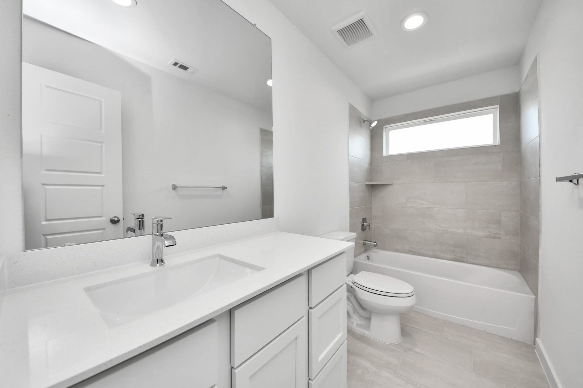 3064 Spoolwood Trail, Magnolia, TX 77355 Secondary bath features tile flooring, bath/shower combo with tile surround, light stained wood cabinets, beautiful light countertop.