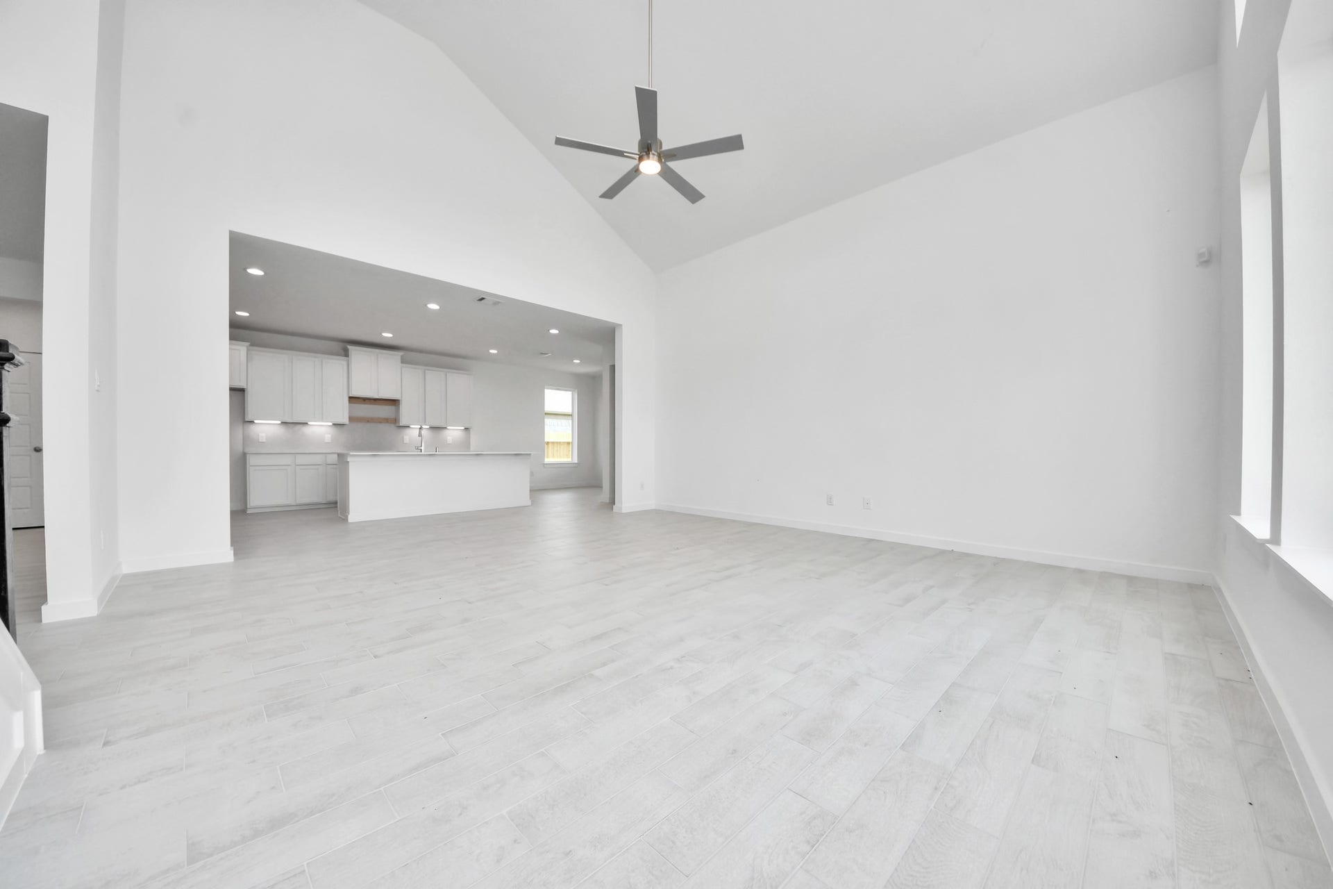 3064 Spoolwood Trail, Magnolia, TX 77355 Family room flooded with natural light through the expansive windows. The premium tile flooring adds a touch of luxury to the space, creating the perfect setting for relaxing moments and cherished gatherings with loved ones
