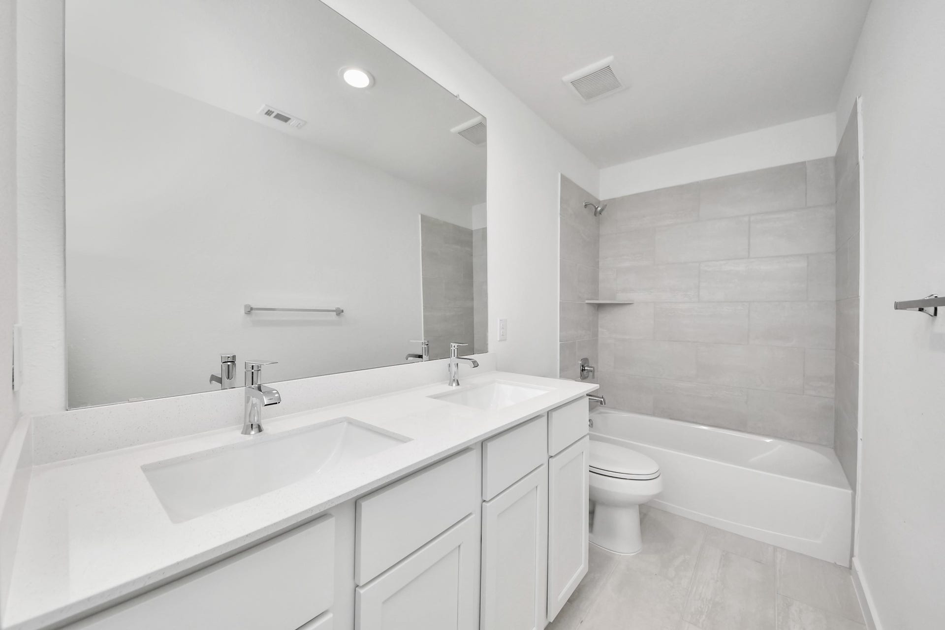 3064 Spoolwood Trail, Magnolia, TX 77355 Secondary bath features tile flooring, bath/shower combo with tile surround, light stained wood cabinets, beautiful light countertop.