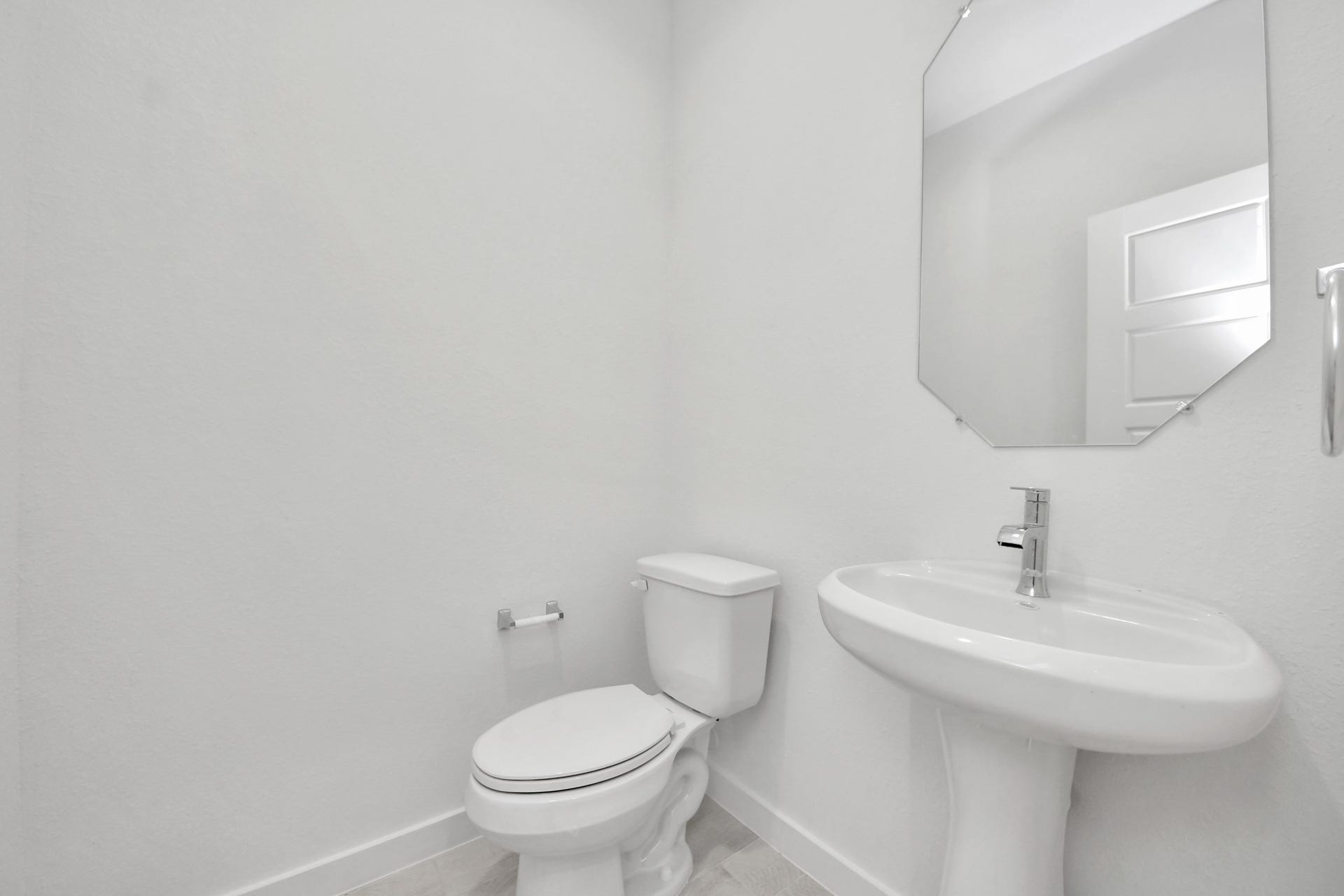 3064 Spoolwood Trail, Magnolia, TX 77355 This half bathroom features a stylish pedestal sink, modern hardware, and bright recessed lighting, creating a sleek and inviting space.