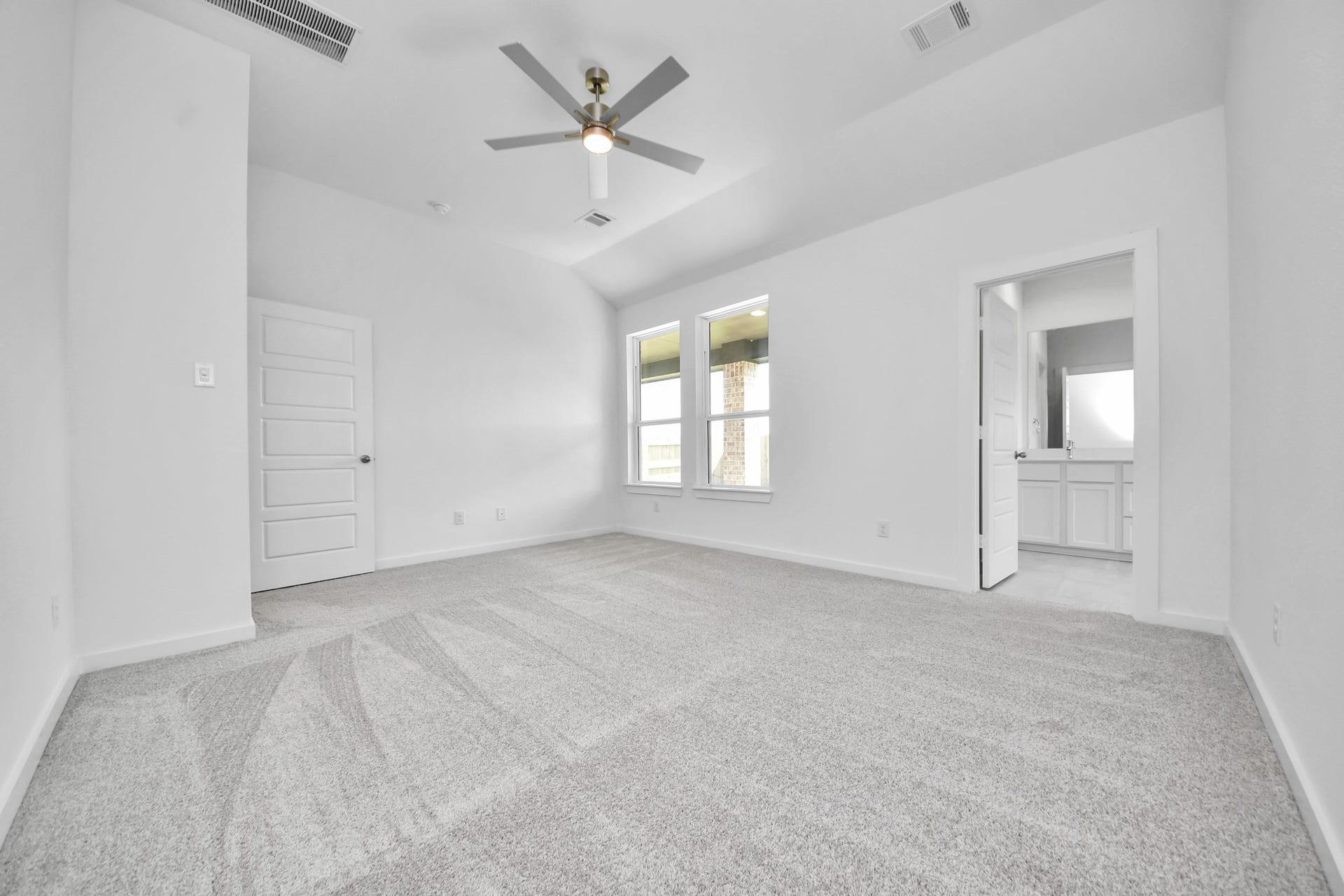 3064 Spoolwood Trail, Magnolia, TX 77355 Retreat to the luxurious primary suite, your perfect escape for unwinding after a long day. Located on the first floor, this spacious room features plush carpeting, calming paint tones, high ceilings, and large windows with privacy blinds.
