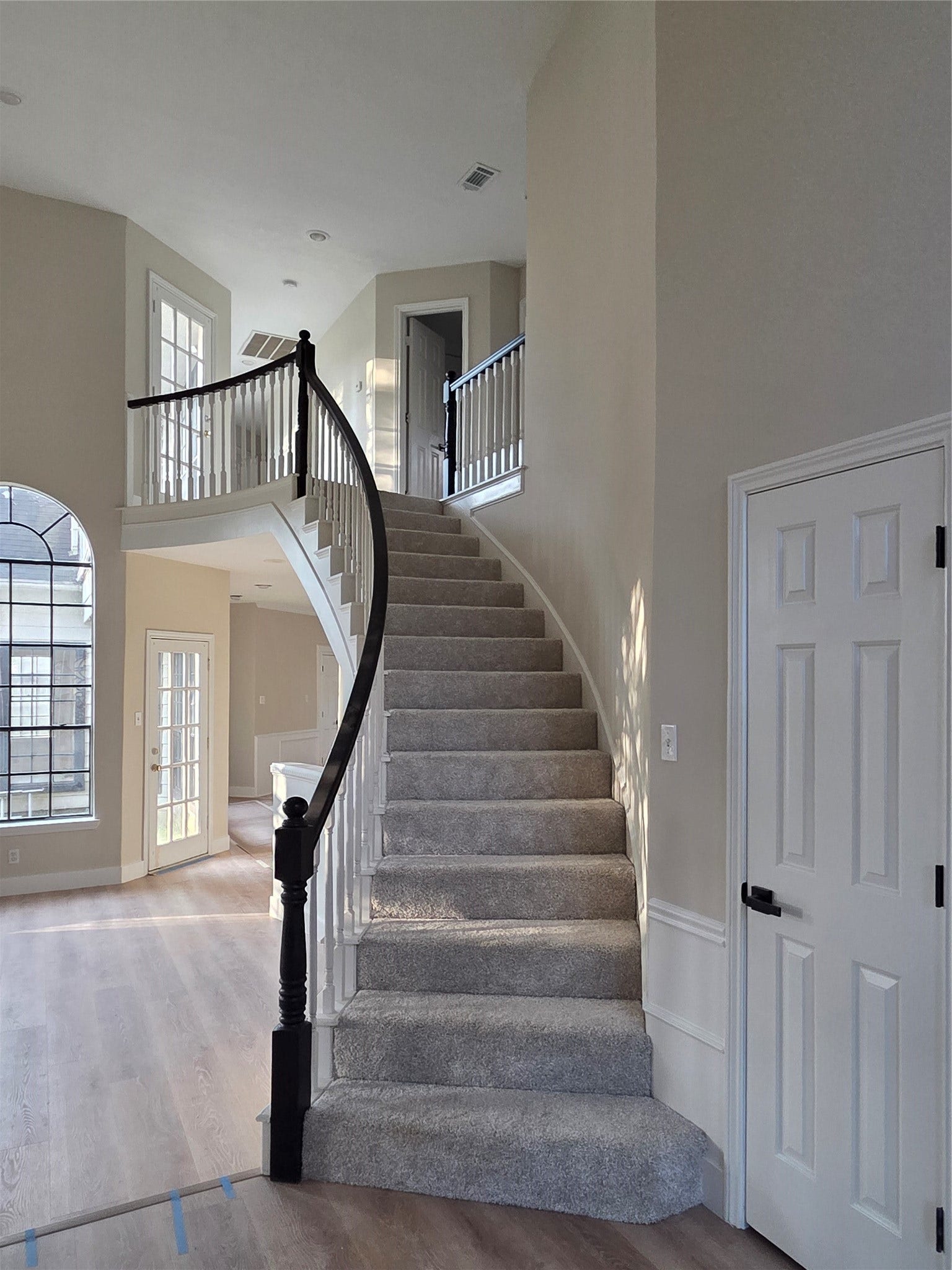 414 Mill Place CT, Sugar Land, TX 77498 Welcoming front entrance featuring soaring ceilings, elegant arched windows, and a staircase with contrasting black and white railing