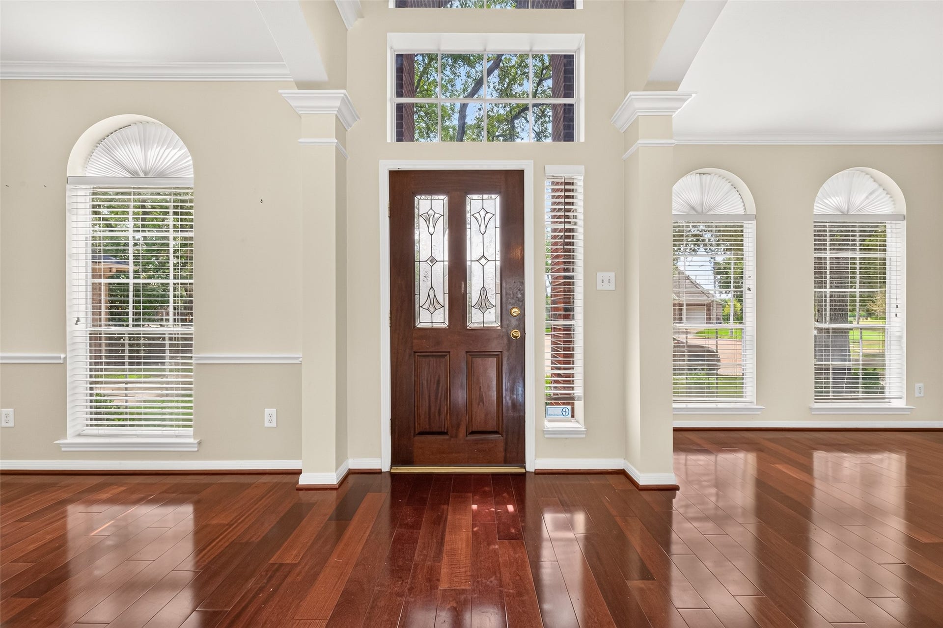 1711 Emma Cove Court, Sugar Land, TX 77479 Sun-filled foyer highlighted by rich wood flooring, soaring ceilings, crown molding, and abundant natural light.