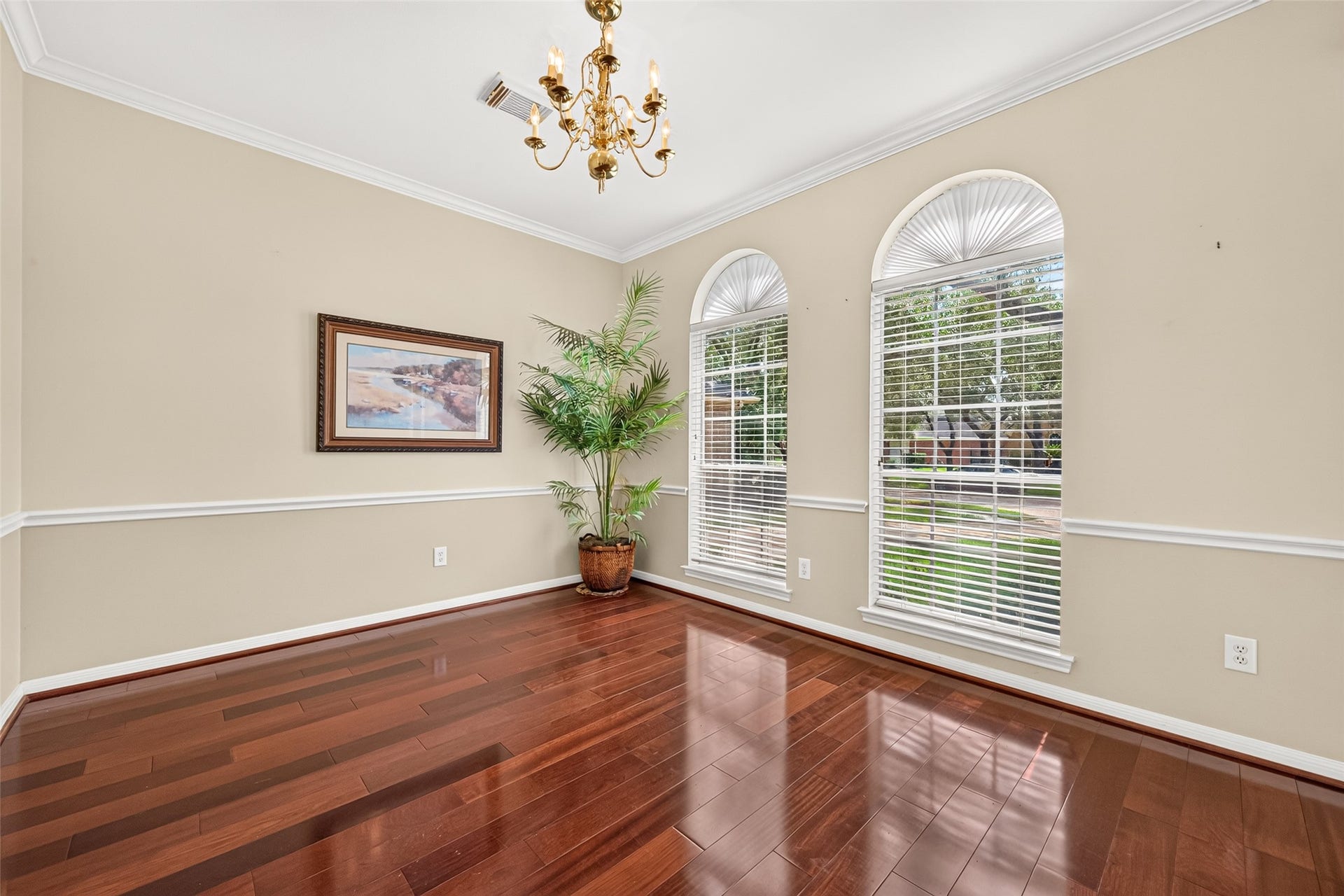 1711 Emma Cove Court, Sugar Land, TX 77479 Formal dining room is appointed with a classic chandelier, chair-rail molding, and rich hardwood floors.