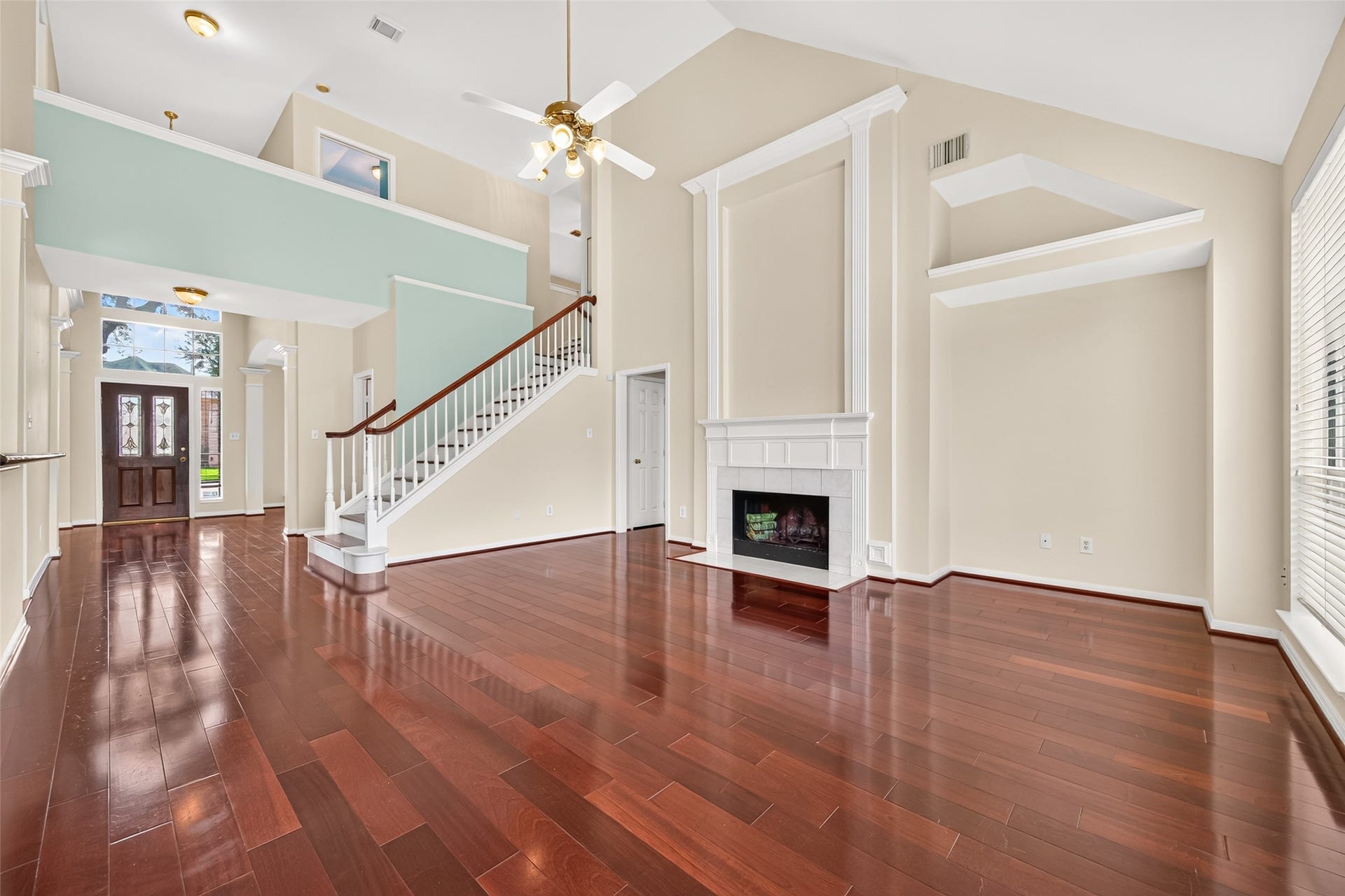 1711 Emma Cove Court, Sugar Land, TX 77479 Dramatic family room showcases a vaulted ceiling, fireplace, built-in display niches, and an open staircase.