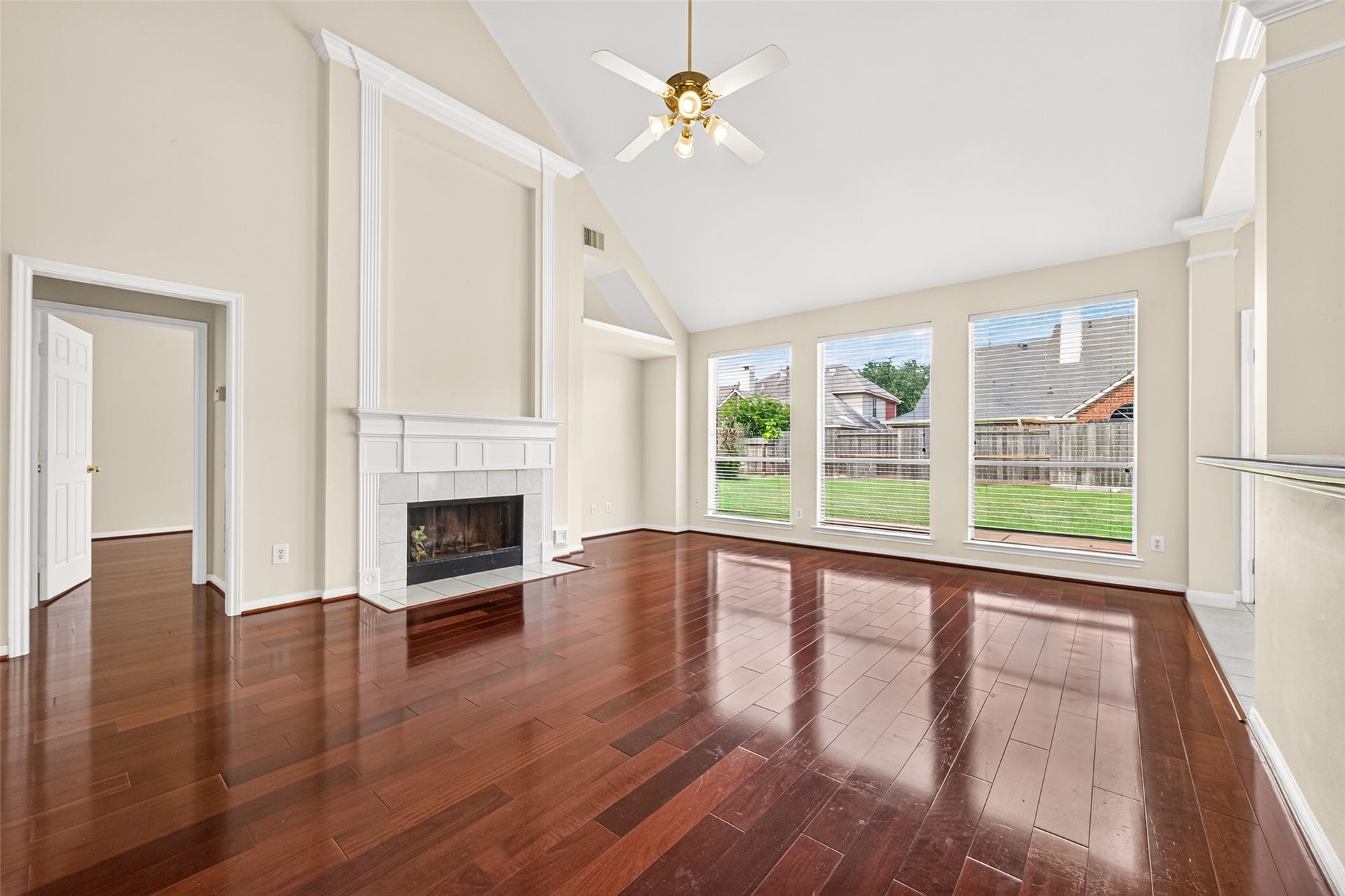 1711 Emma Cove Court, Sugar Land, TX 77479 Soaring ceilings, a fireplace, and a wall of windows give the living room an airy, light-filled atmosphere.