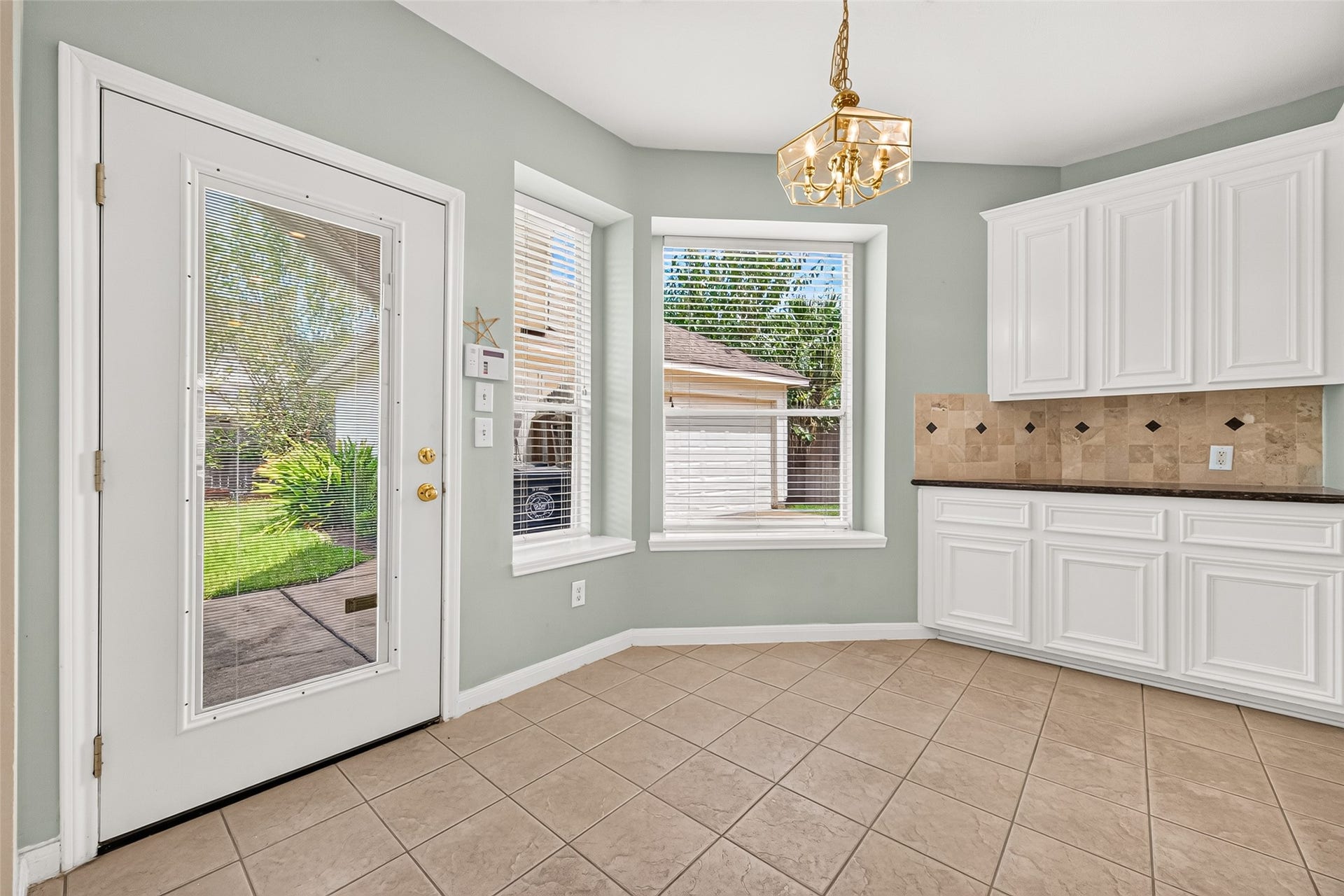 1711 Emma Cove Court, Sugar Land, TX 77479 Sunny breakfast area features bay-style windows, tile flooring, and direct access to the backyard.