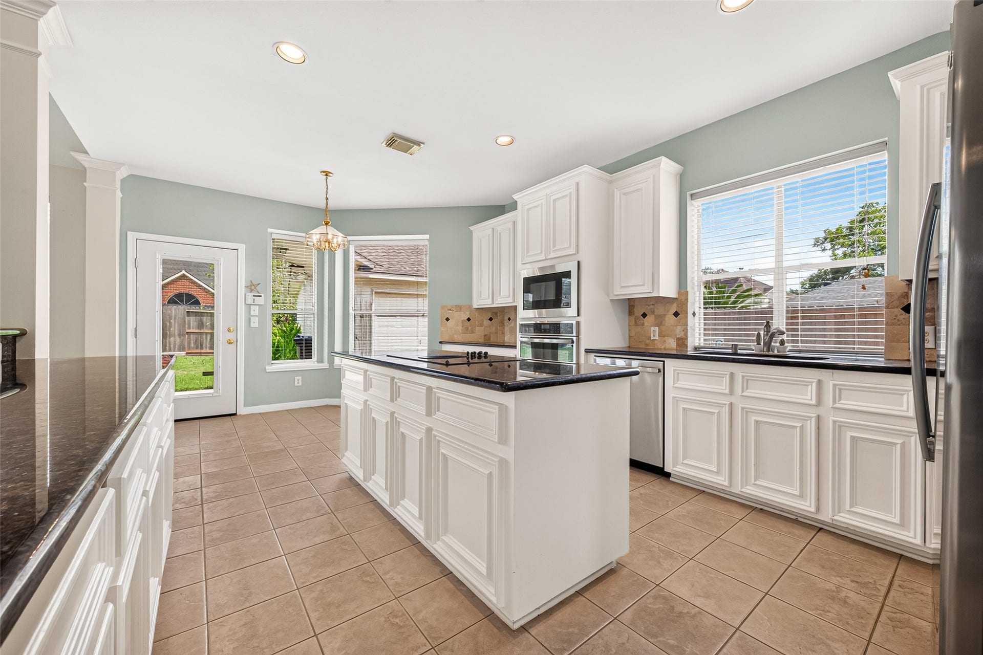 1711 Emma Cove Court, Sugar Land, TX 77479 Open kitchen design connects easily with the living areas and includes ample cabinetry, an island cooktop, and coordinated appliances.