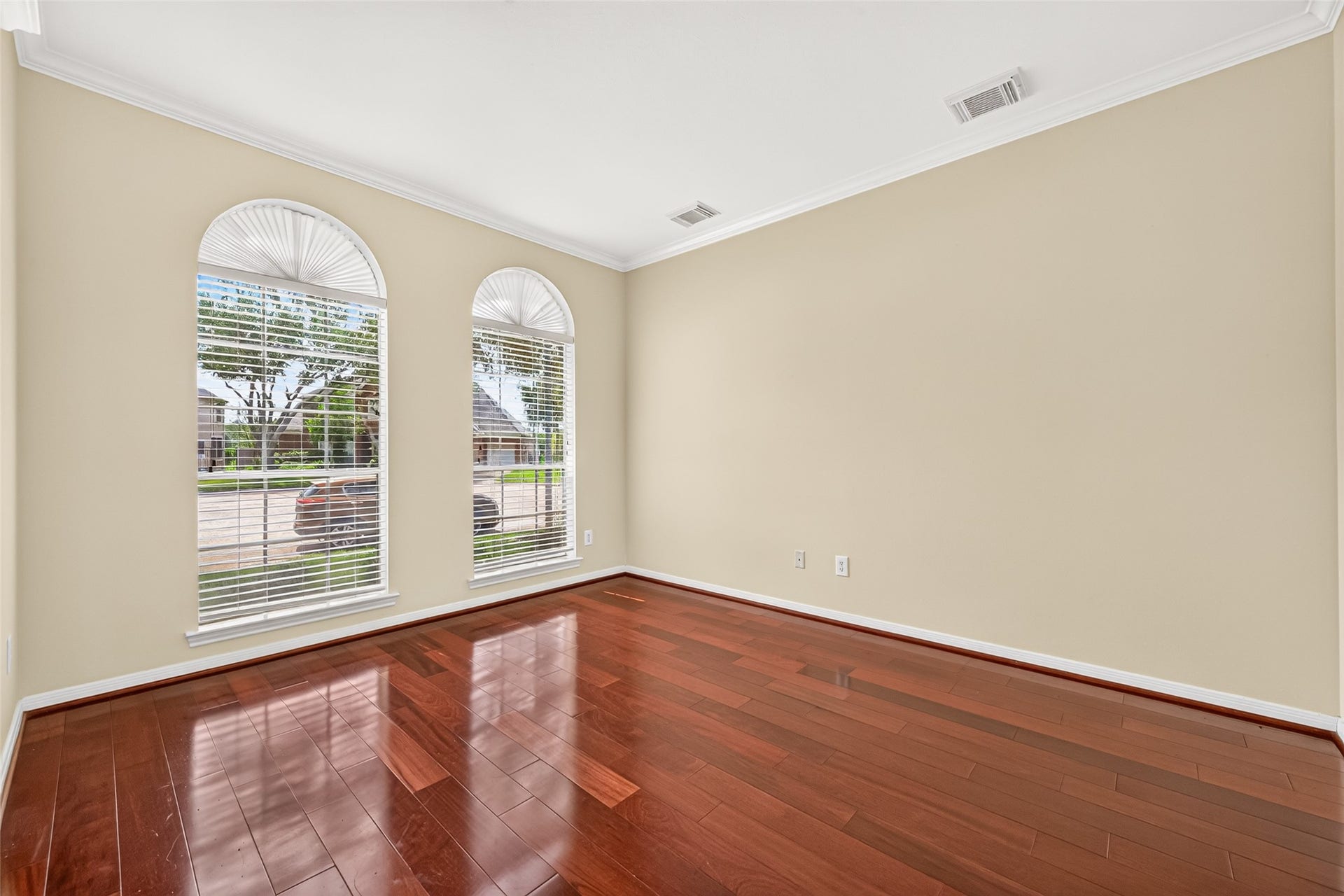 1711 Emma Cove Court, Sugar Land, TX 77479 Versatile front room offers gleaming wood floors, crown molding, and two tall arched windows.