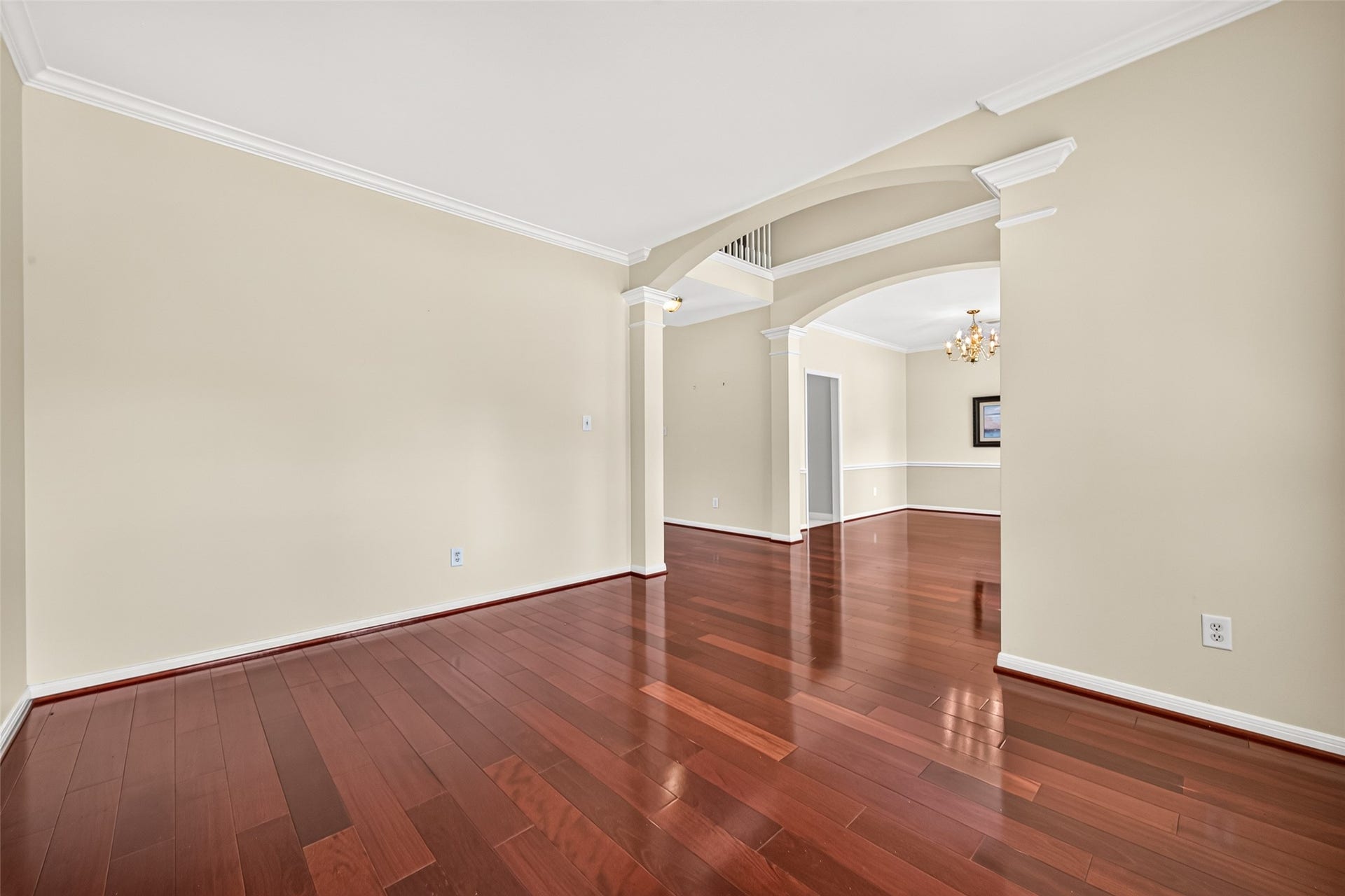 1711 Emma Cove Court, Sugar Land, TX 77479 Generously sized room with warm neutral walls, polished wood flooring, and classic crown molding.
