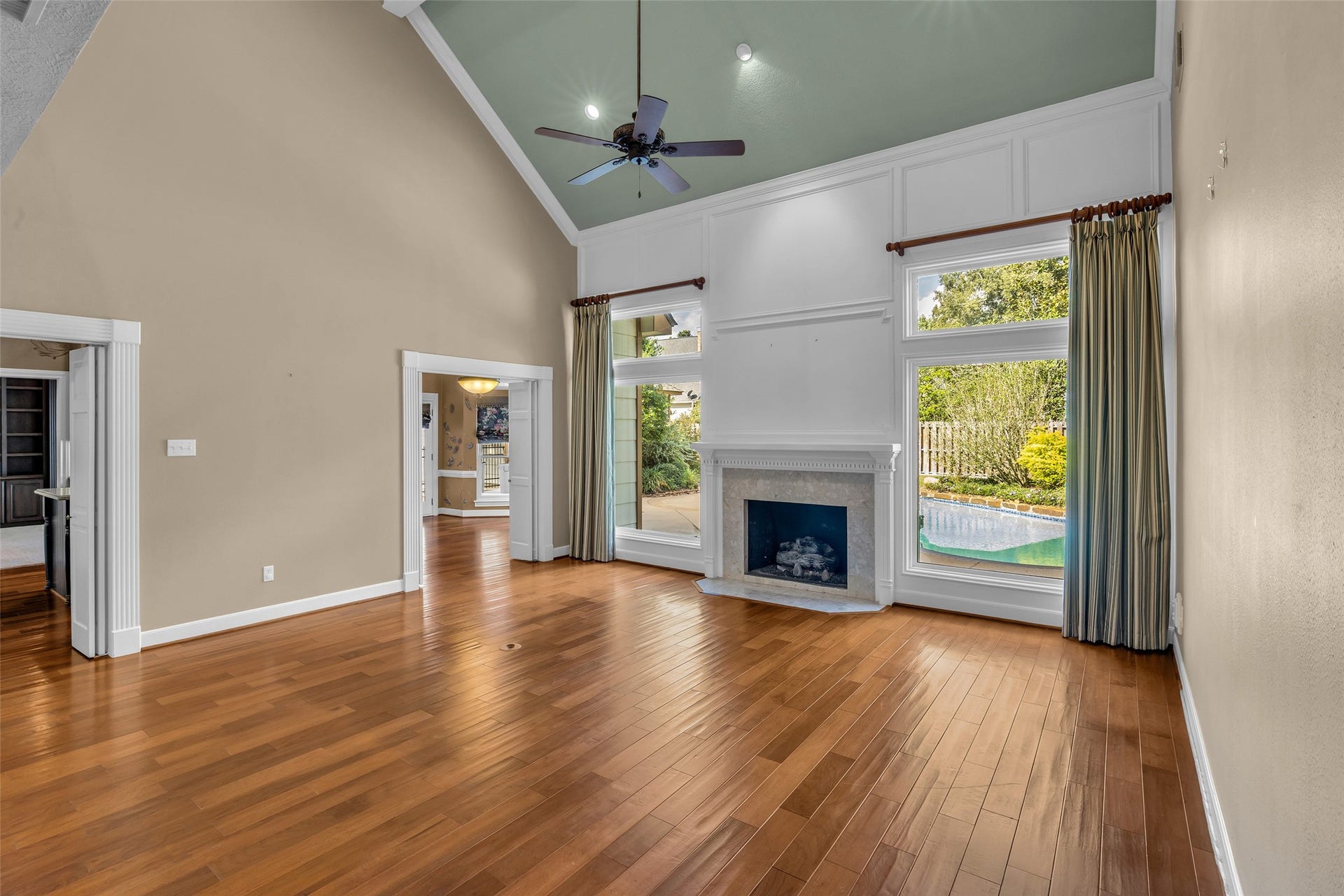5907 Rocky Brook Drive, Houston, TX 77345 Two-story living room with fireplace and views of the private pool.