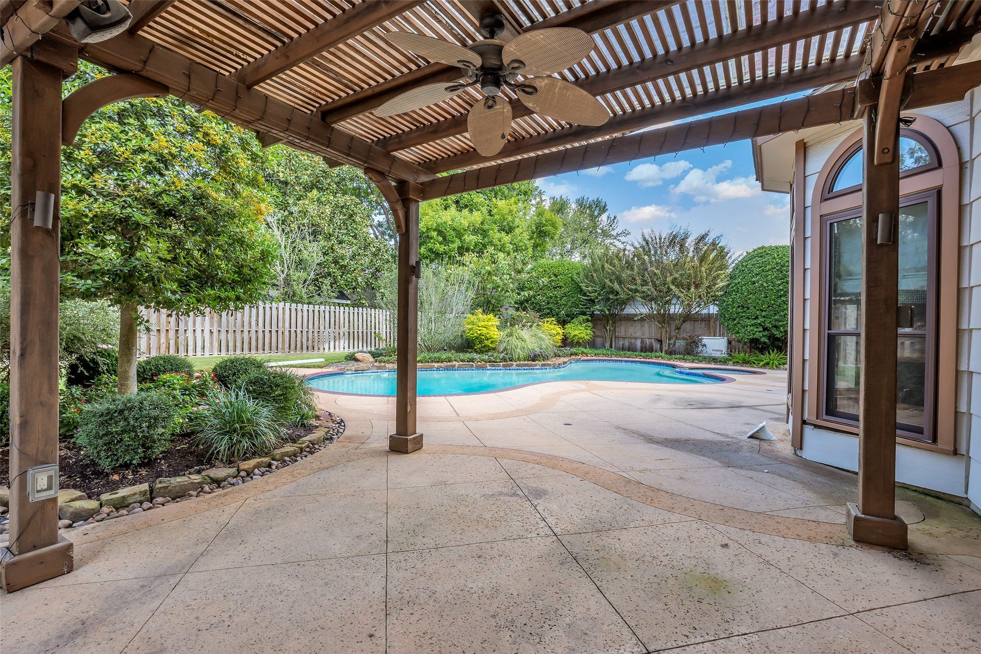 5907 Rocky Brook Drive, Houston, TX 77345 Wood pergola with ceiling fan and string lighting overlooking the pool.