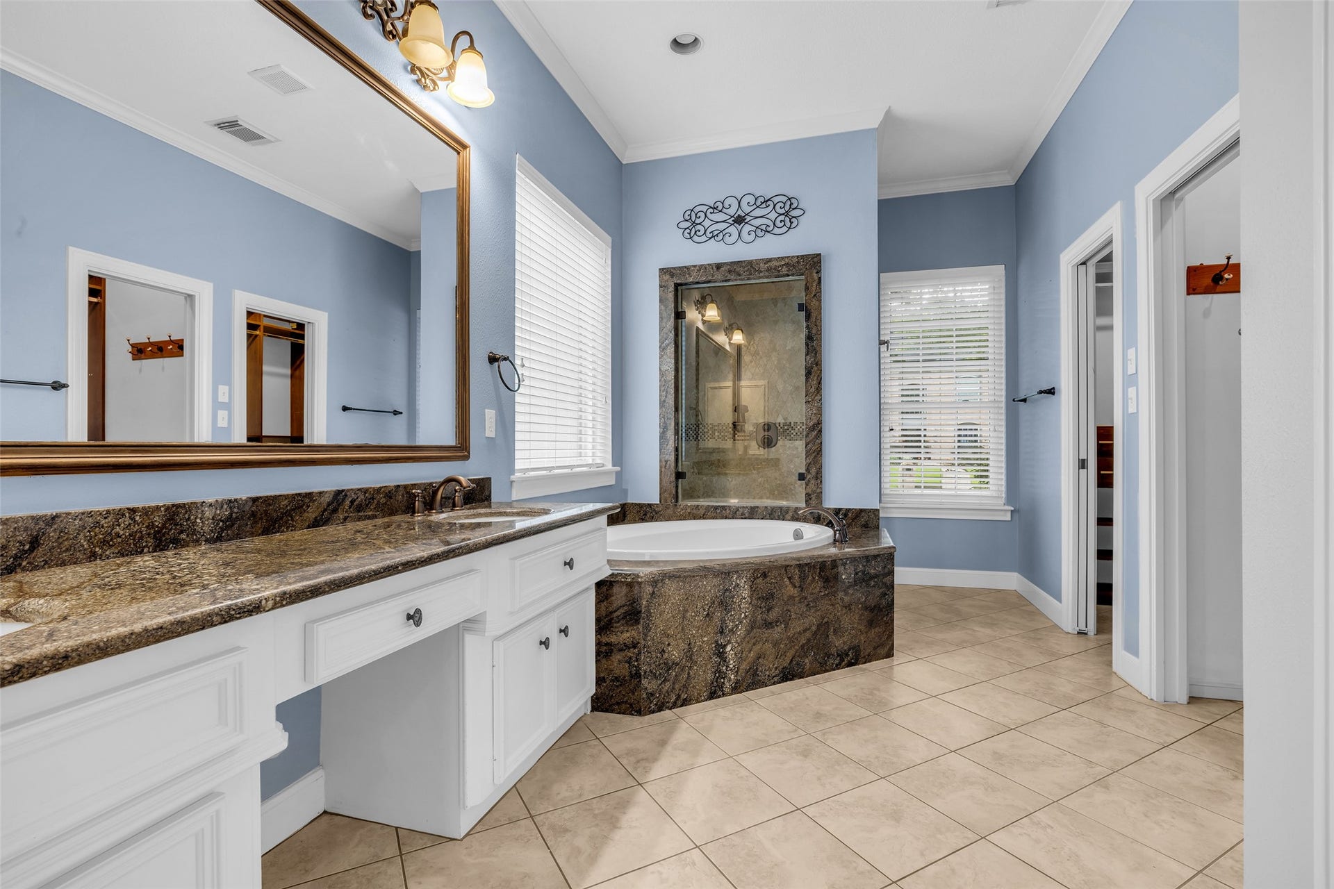 5907 Rocky Brook Drive, Houston, TX 77345 Spacious primary bathroom with granite countertops, soaking tub, separate glass-enclosed shower, two walk-in-closets
