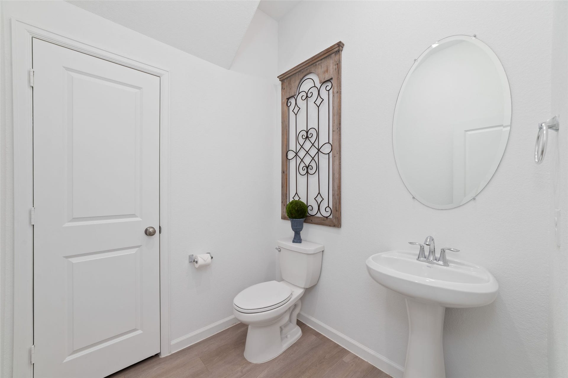 5715 Foggy Vine Court, Fulshear, TX 77441 The convenient main-level half bathroom features a pedestal sink, decorative mirror, and neutral finishes, providing easy access for guests and everyday use.