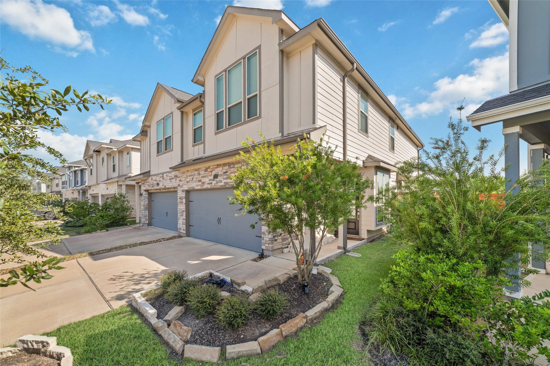 5715 Foggy Vine Court, Fulshear, TX 77441 Built in 2022, this attractive corner-unit townhome features traditional architecture, stone accents, manicured landscaping, and a welcoming exterior.