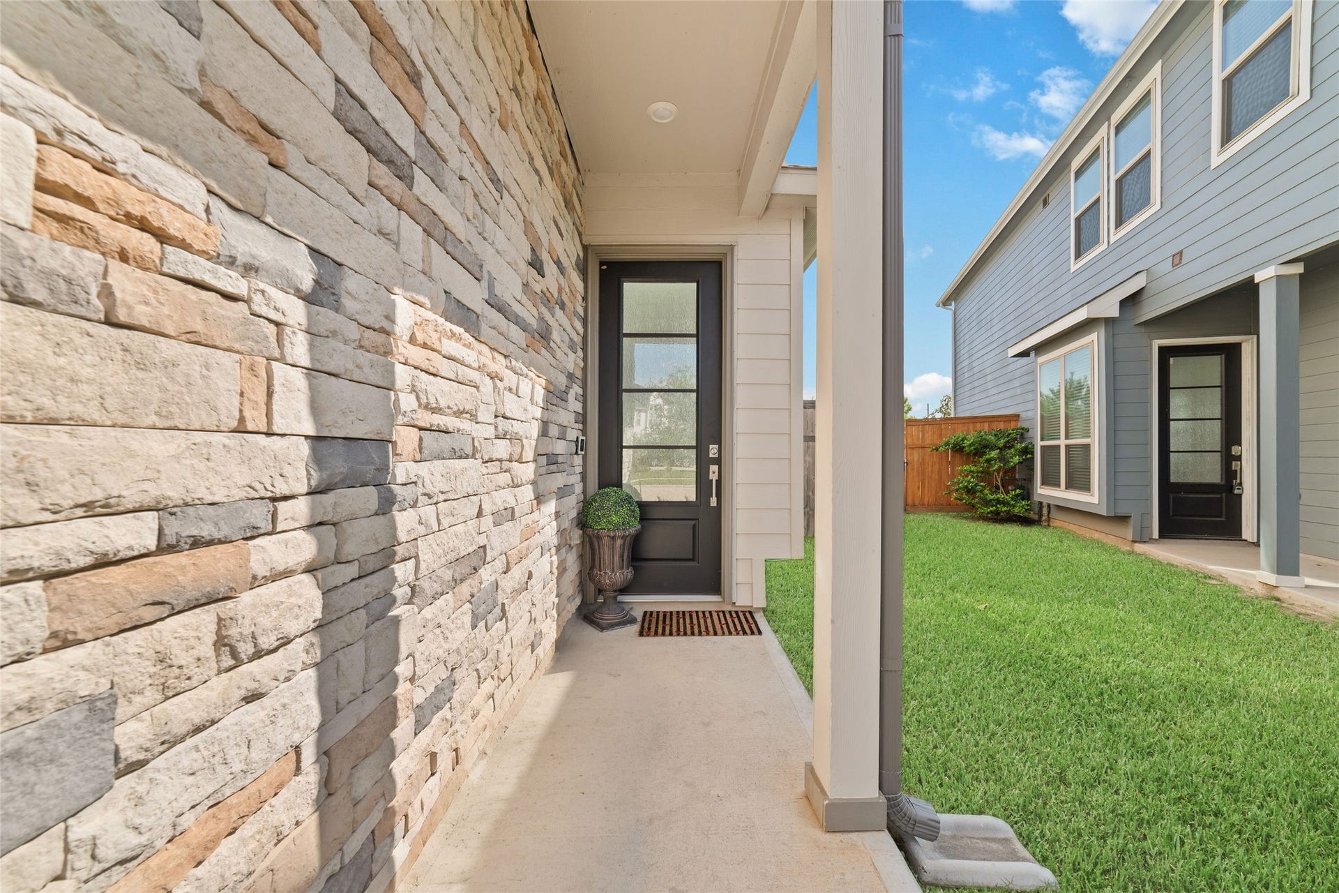 5715 Foggy Vine Court, Fulshear, TX 77441 A covered front entry with beautiful stone detailing welcomes you home, offering a convenient walkway and easy access to the residence.
