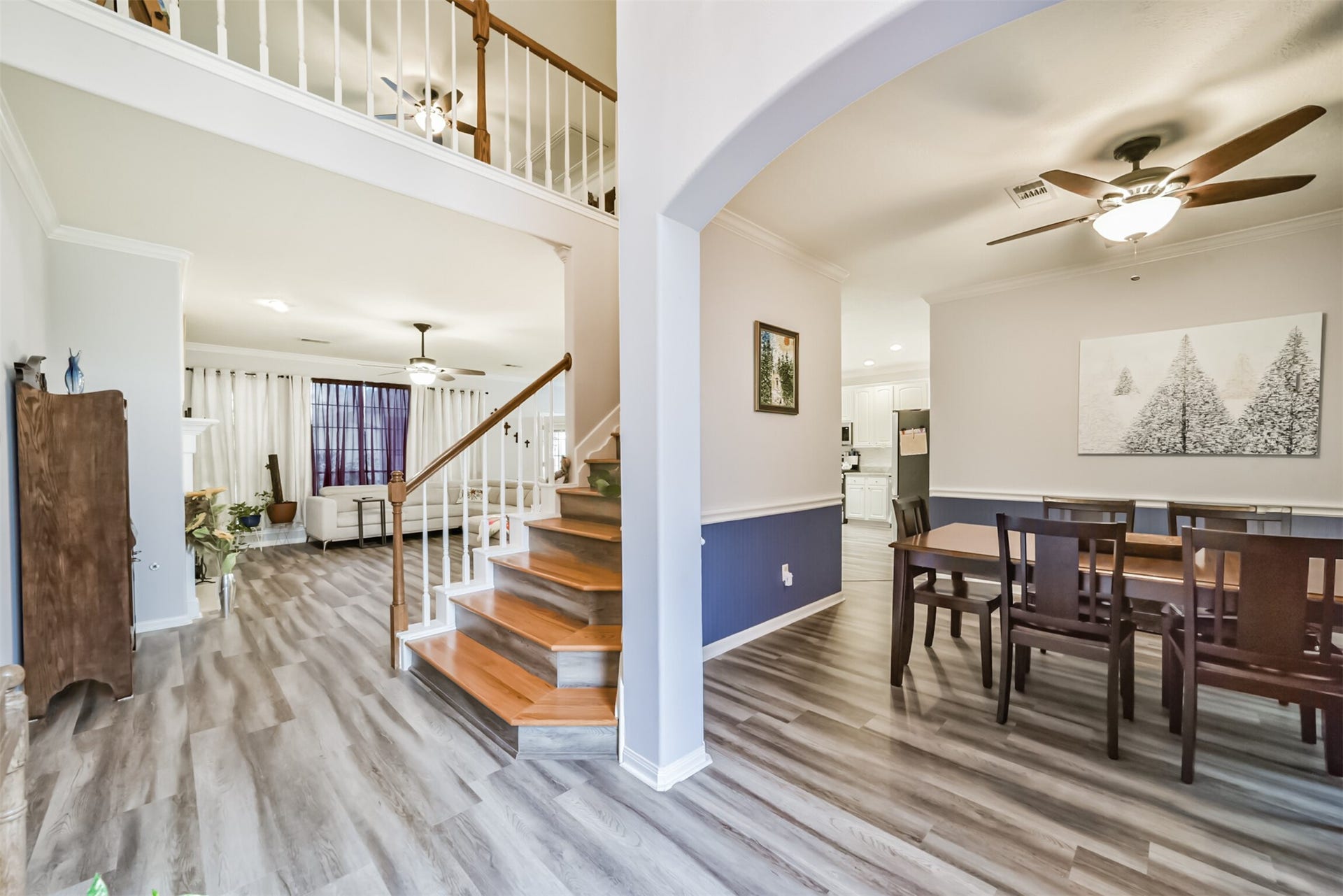 18402 Spinner Court Drive, Humble, TX 77346 A view of the formal dining room, with its arched entry and the wooden staircase beyond, rising to the upper level with turned wood balusters and a matching banister.
