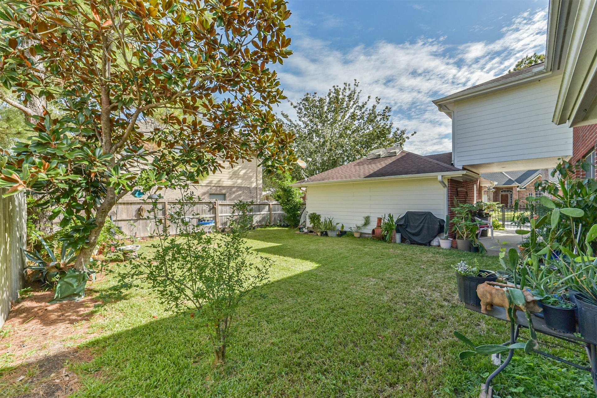 18402 Spinner Court Drive, Humble, TX 77346 A private backyard enclosed by a fence, featuring a patio nestled between the garage and the house.