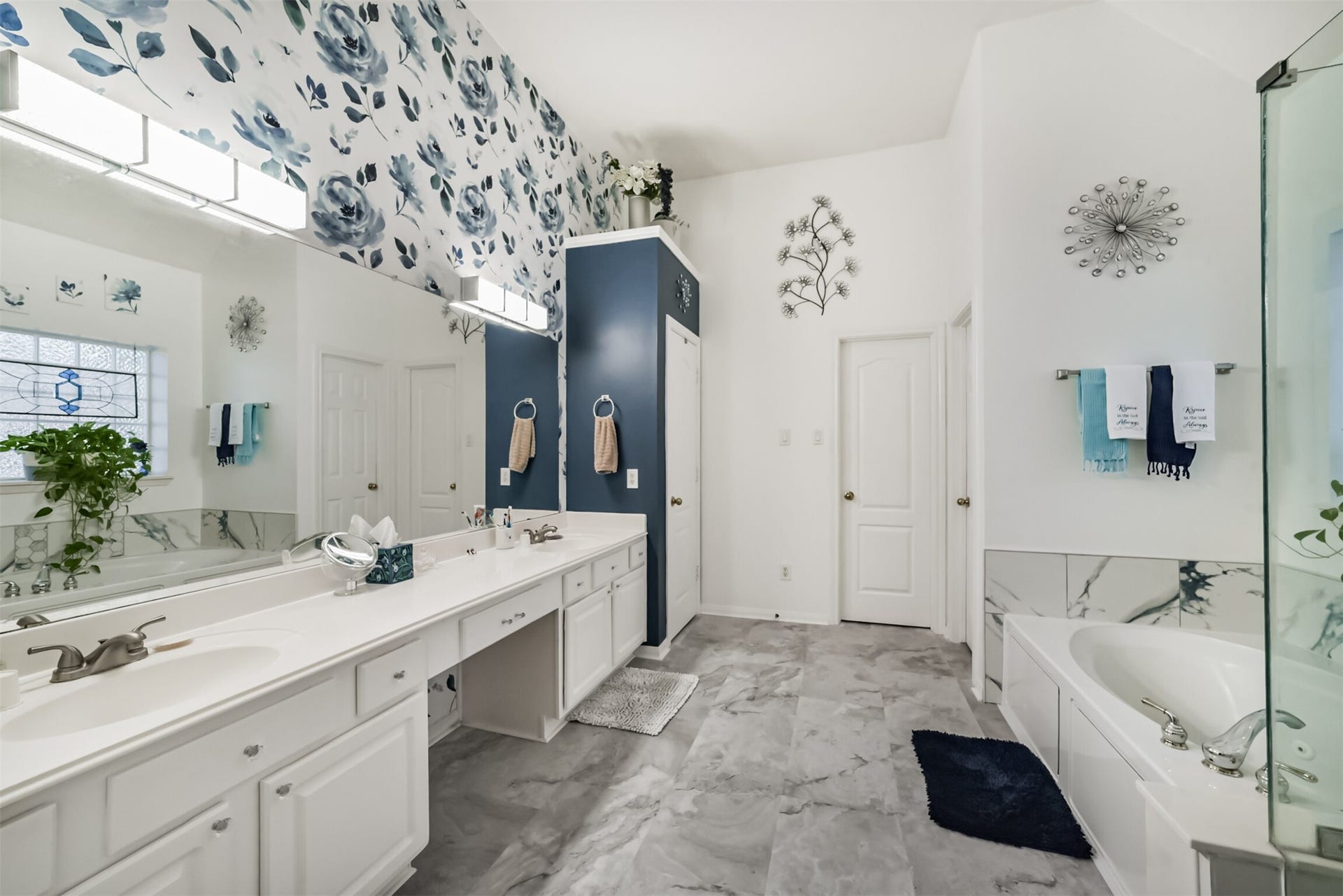 18402 Spinner Court Drive, Humble, TX 77346 The primary bathroom features a cultured marble vanity with dual sinks and a built-in makeup desk, along with a private water closet and a jetted soaking tub with a separate shower.