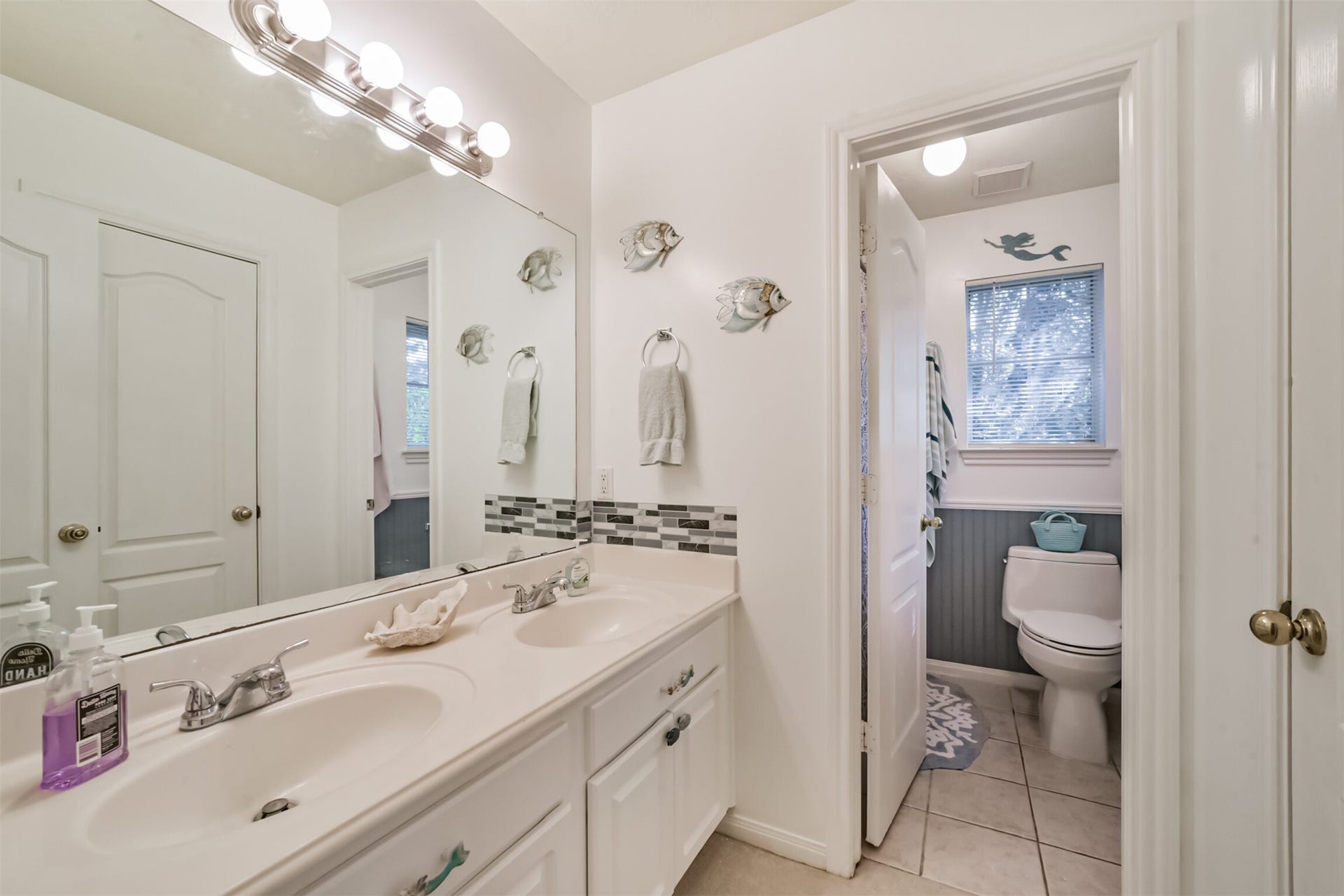 18402 Spinner Court Drive, Humble, TX 77346 The upstairs full bathroom features a cultured marble vanity with dual sinks and a private water closet.