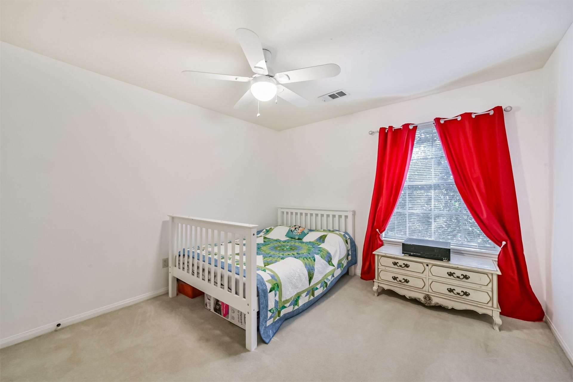18402 Spinner Court Drive, Humble, TX 77346 Upstairs bedroom 3 features a ceiling fan with an integrated light fixture, along with blinds and curtains for window treatments.